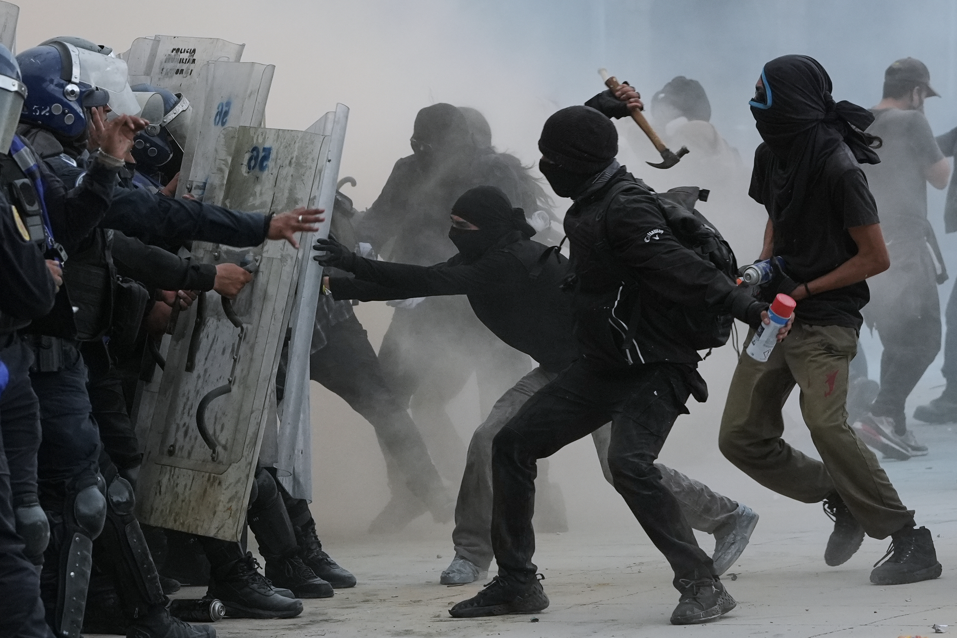 Demonstrators and riot police face off during a protest commemorating the anniversary of the 1968 Tlatelolco killings, when soldiers fired on student protesters, in Mexico City, on October 2, 2025. 