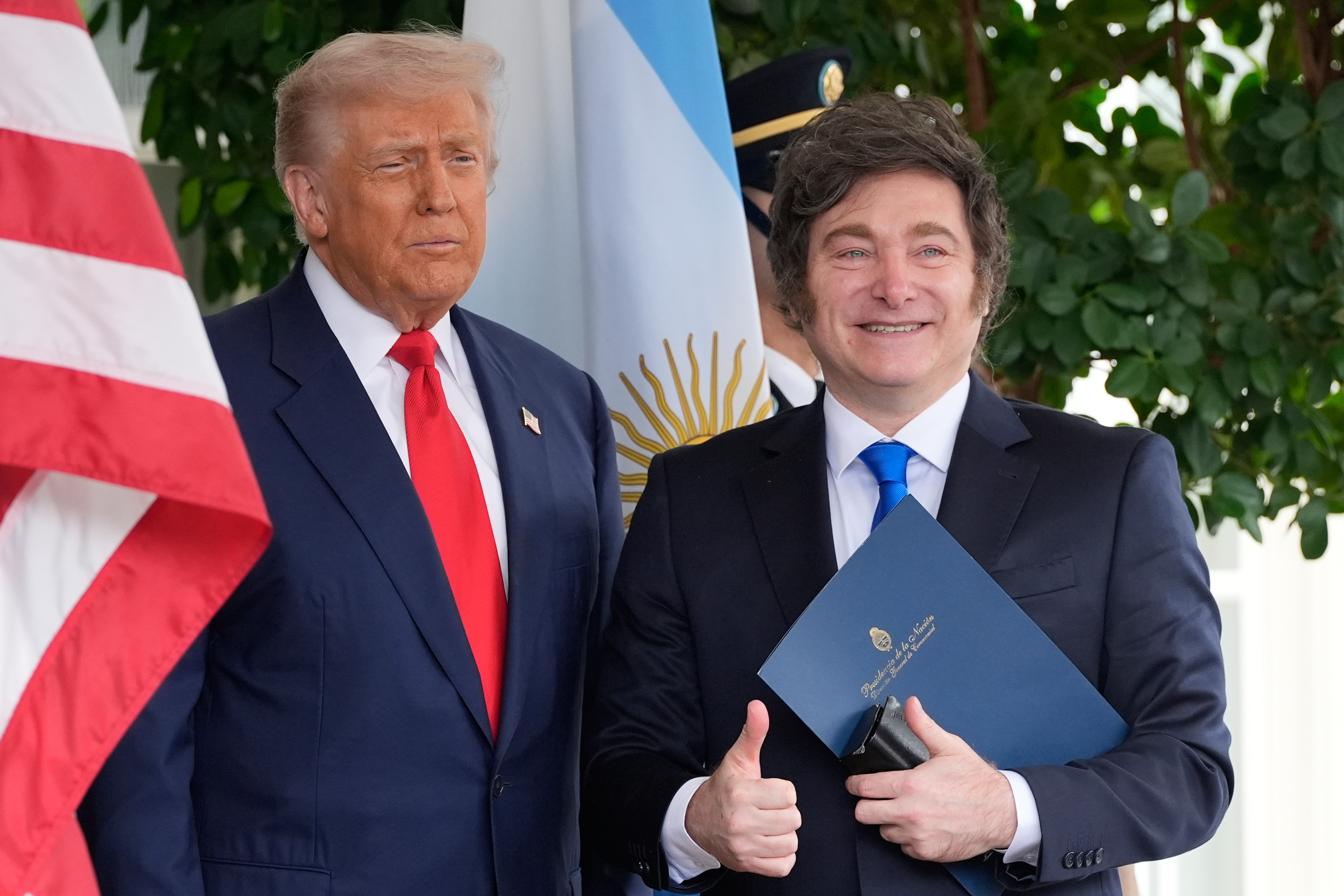 Donald Trump next to Javier Milei, who gives a thumbs-up.