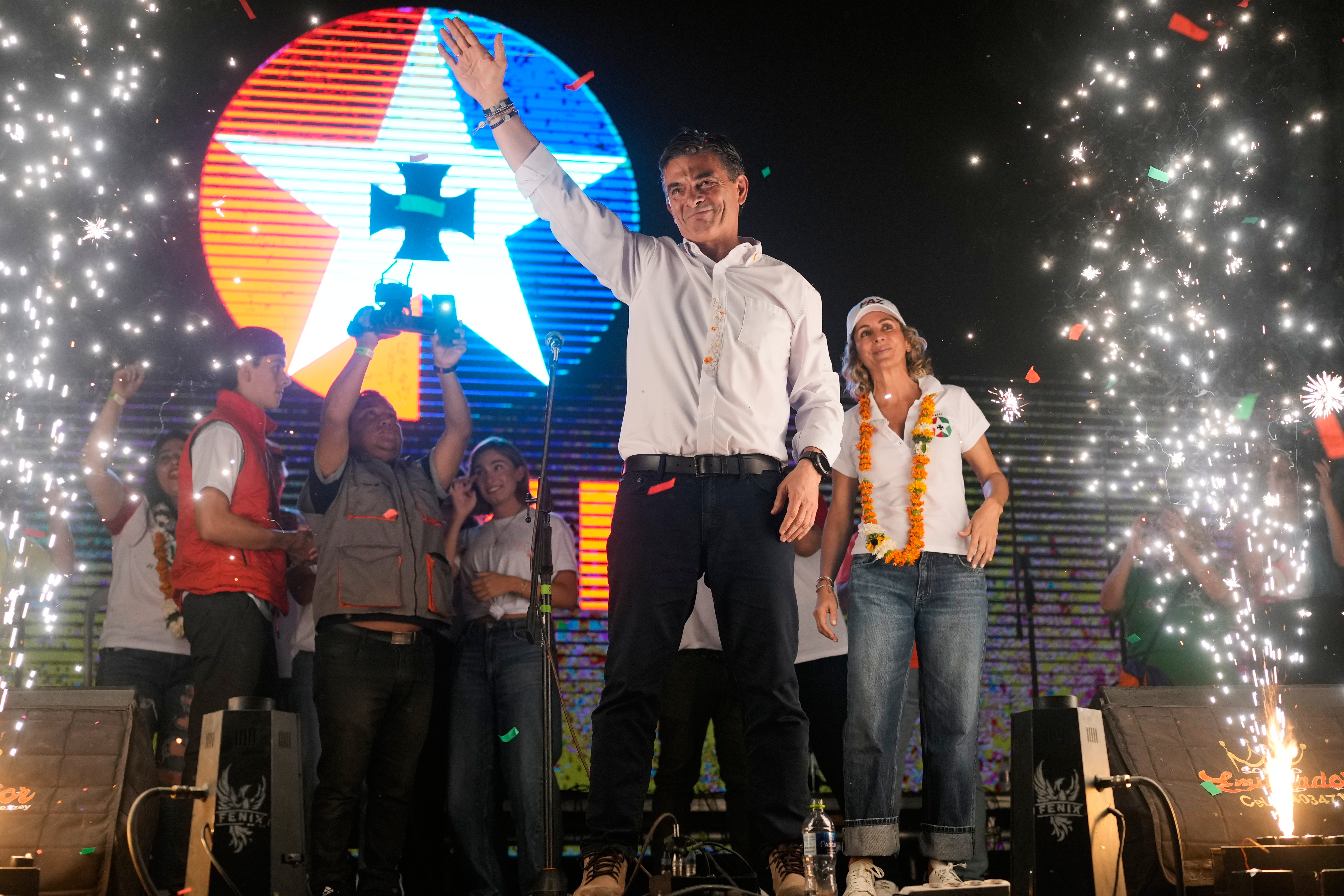 FOR BRIAN OSGOOD Rodrigo Paz stands on stage at a rally with supporters as small fireworks go off to either side