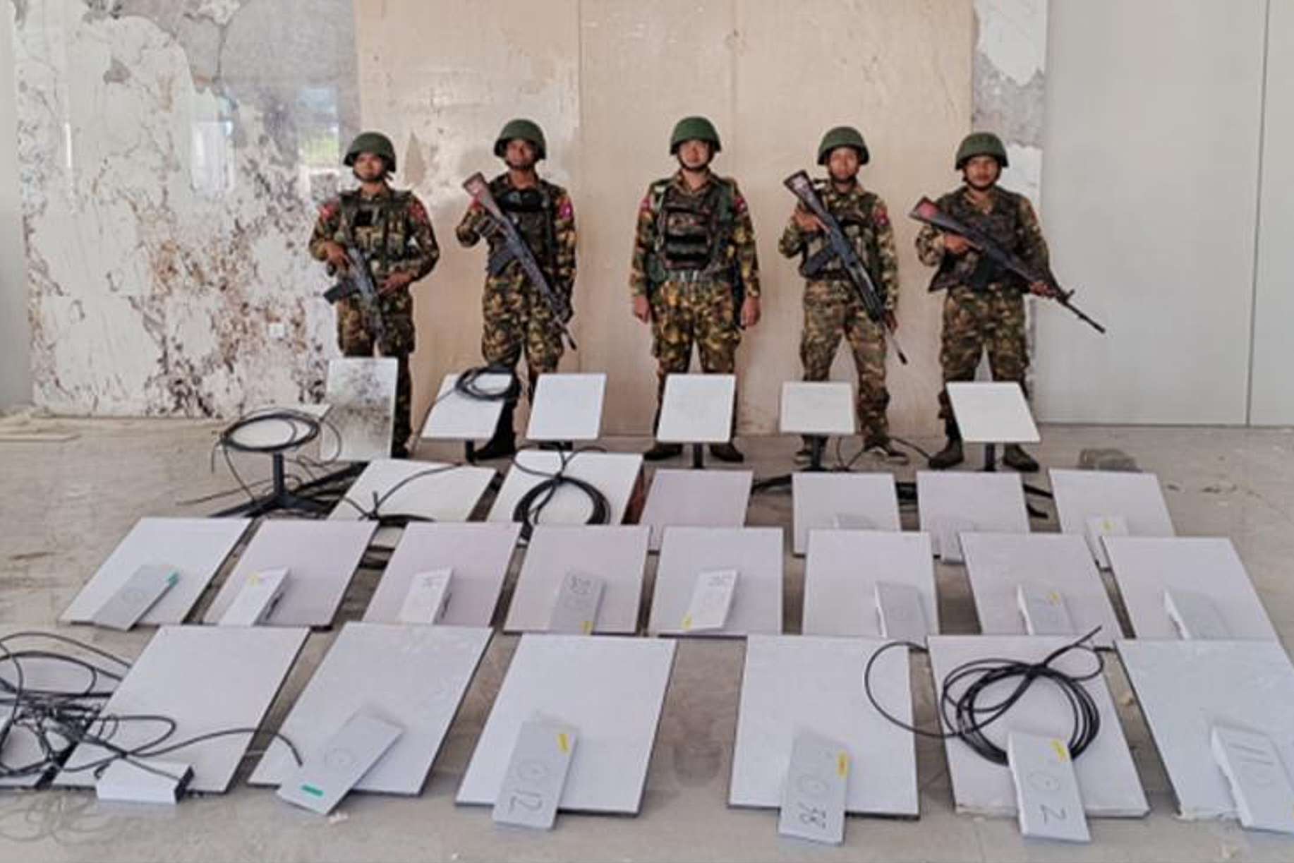 In this image provided by the Myanmar military on Oct. 19, 2025, soldiers stand next to Starlink machines as they seize KK Park online scam center in Myawaddy township, Karen State, Myanmar. (The Myanmar Military True News Information Team via AP)
