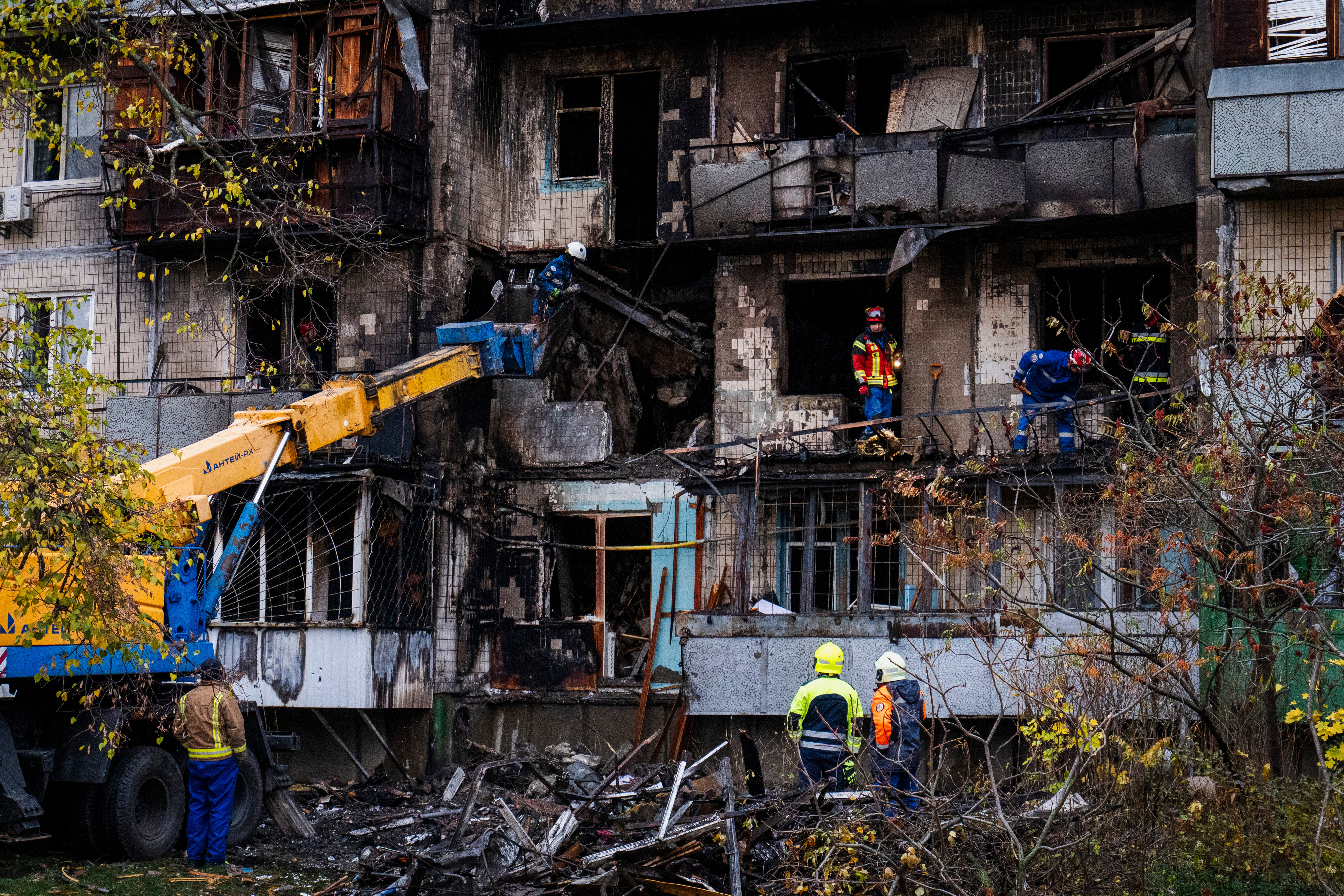 Firefighters work at a destroyed apartment building.
