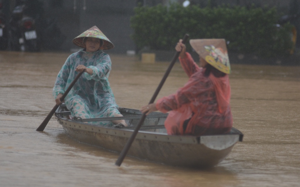 People paddle a boat on a flooded street in Hue, Vietnam
