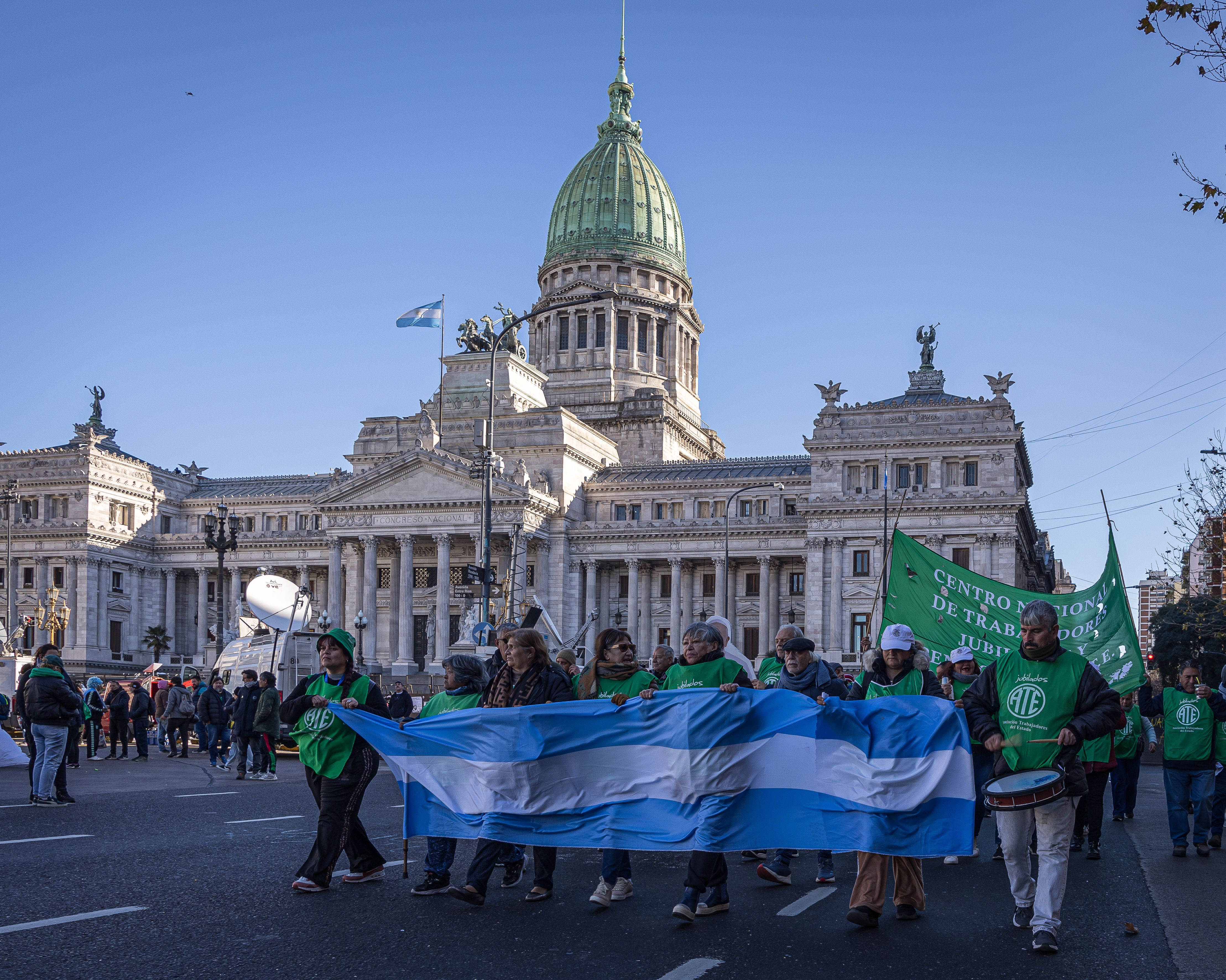 Protesters march with a blue-and-white banner outside of Argentina's Congress.