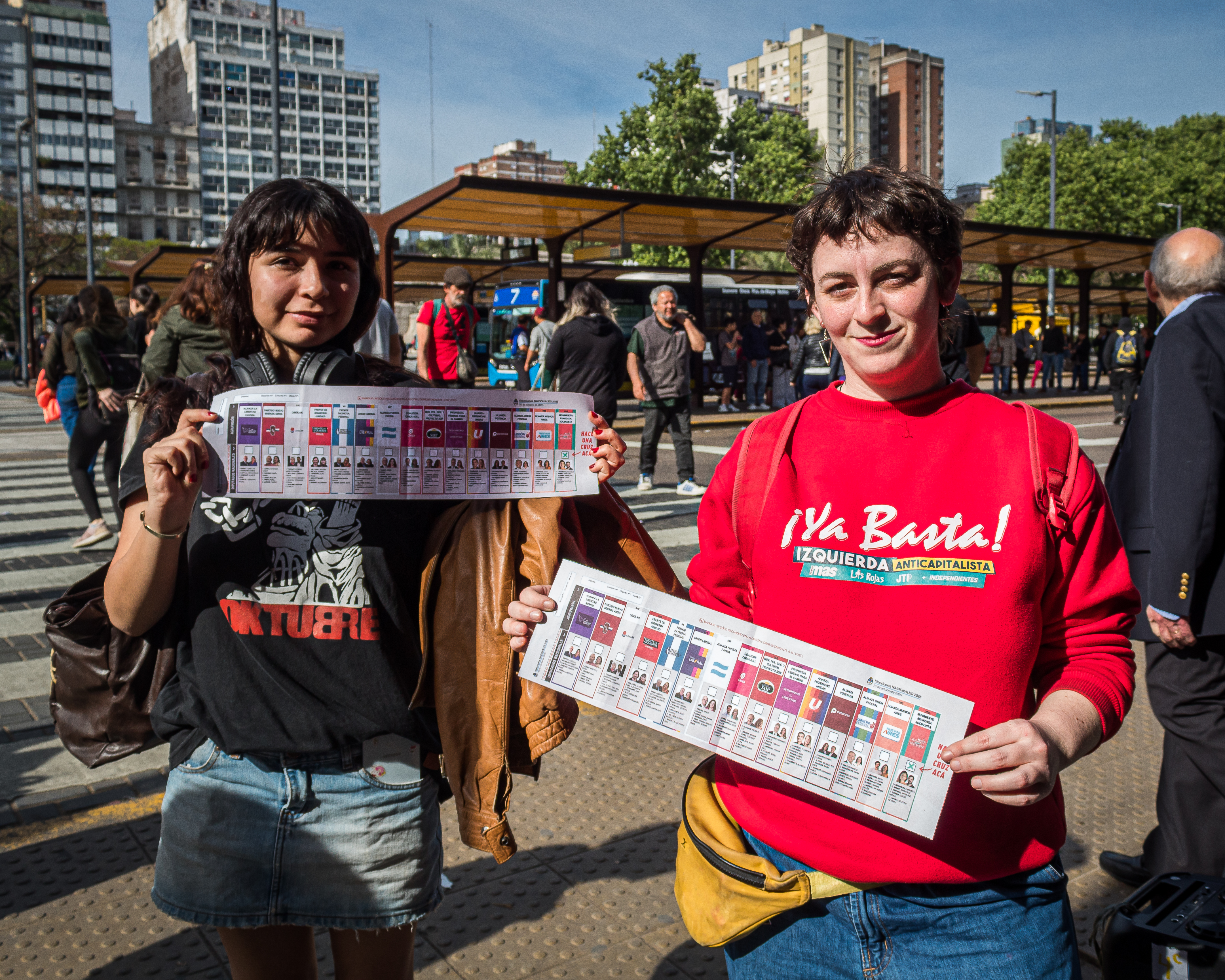 Two advocates hold up mock ballots to help explain the new voting system.