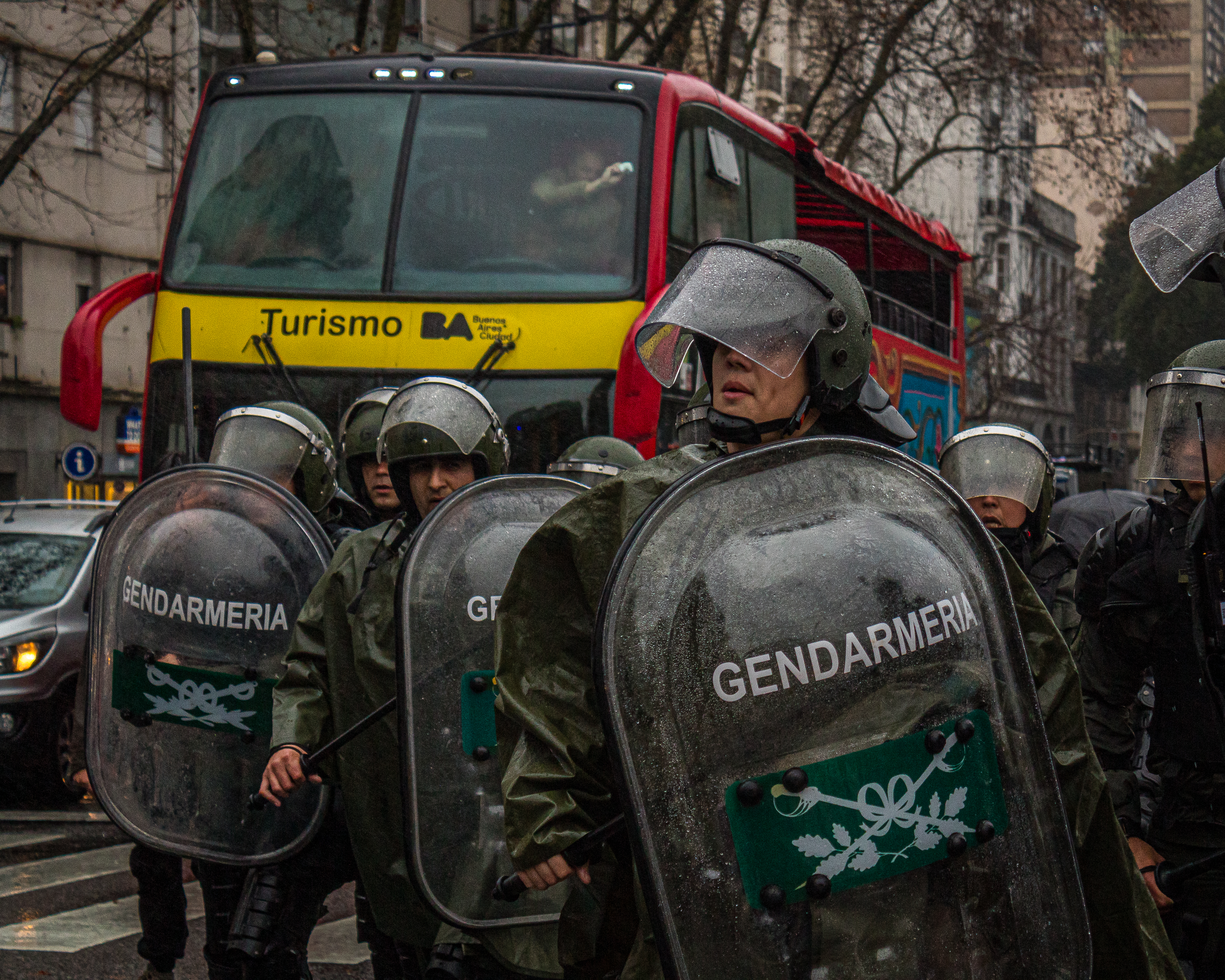 Police in riot gear stand in front of a tourism bus in Argentina