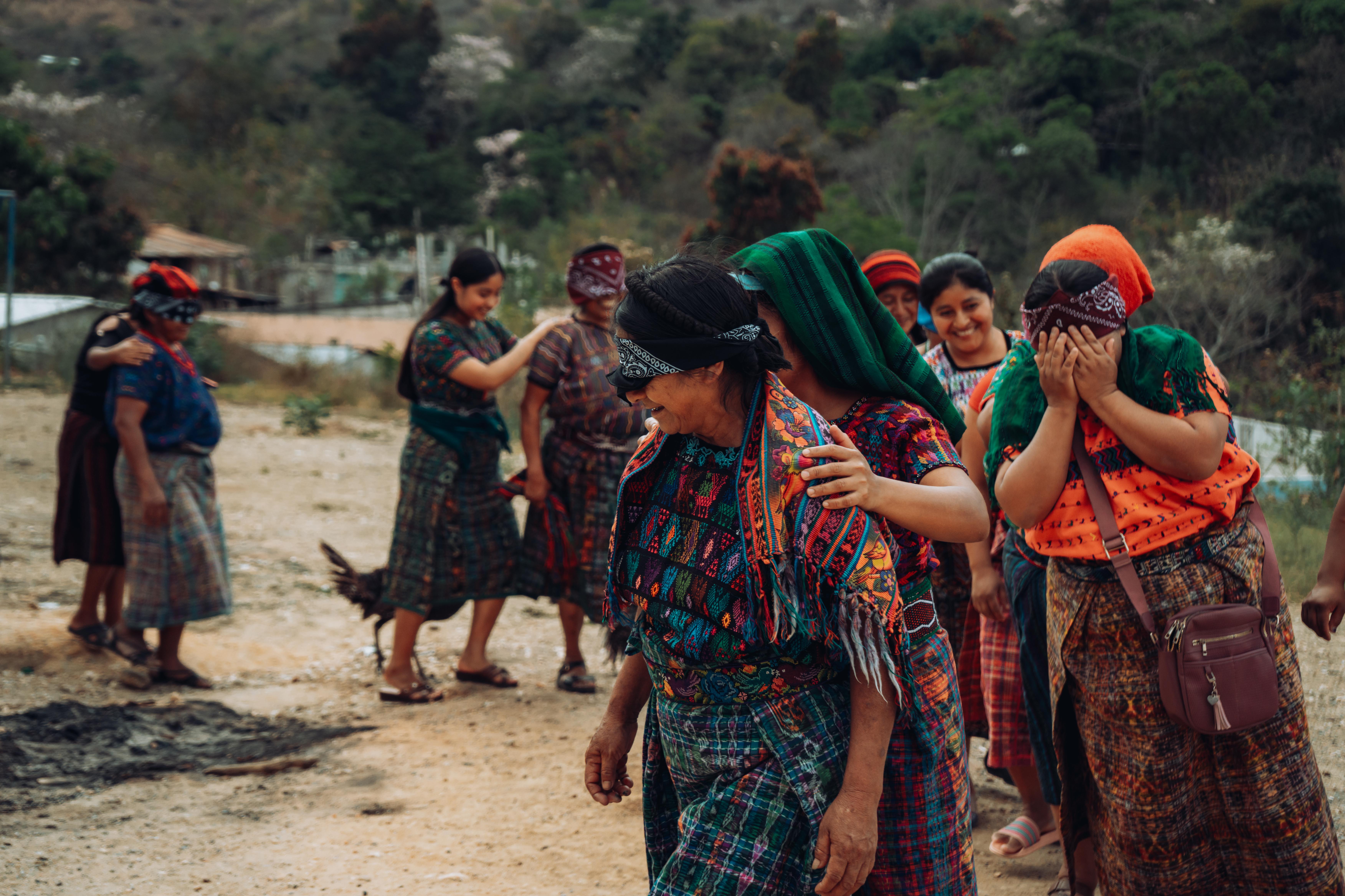 Women in Santa Apolonia practice guided drawing while blindfolded, an exercise highlighting the value of trust, support, and interdependence.