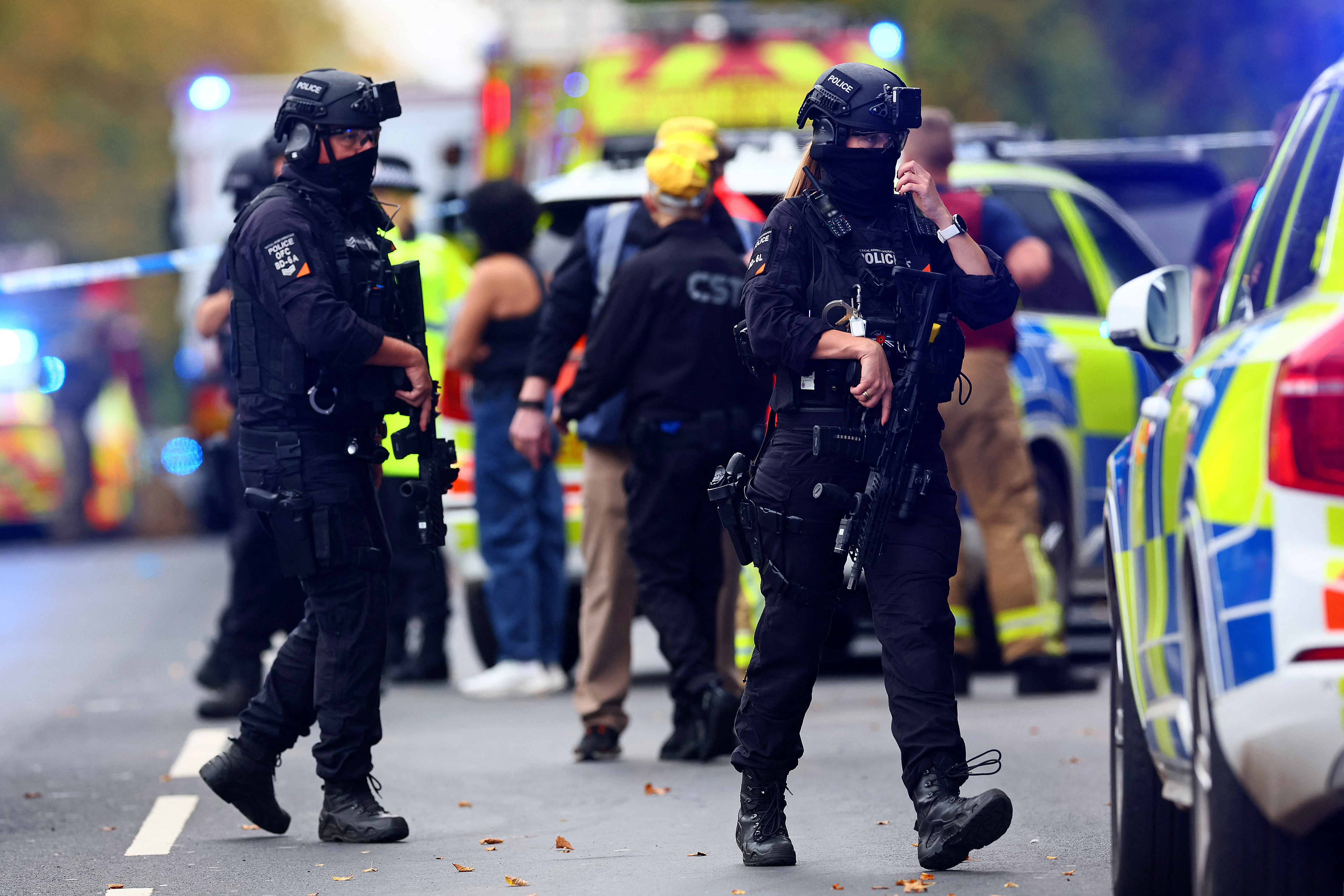 Armed police officers stand with their weapons inside a Police cordon near Heaton Park Hebrew Congregation synagogue in Crumpsall, north Manchester, on October 2, 2025, following an incident at the synagogue.