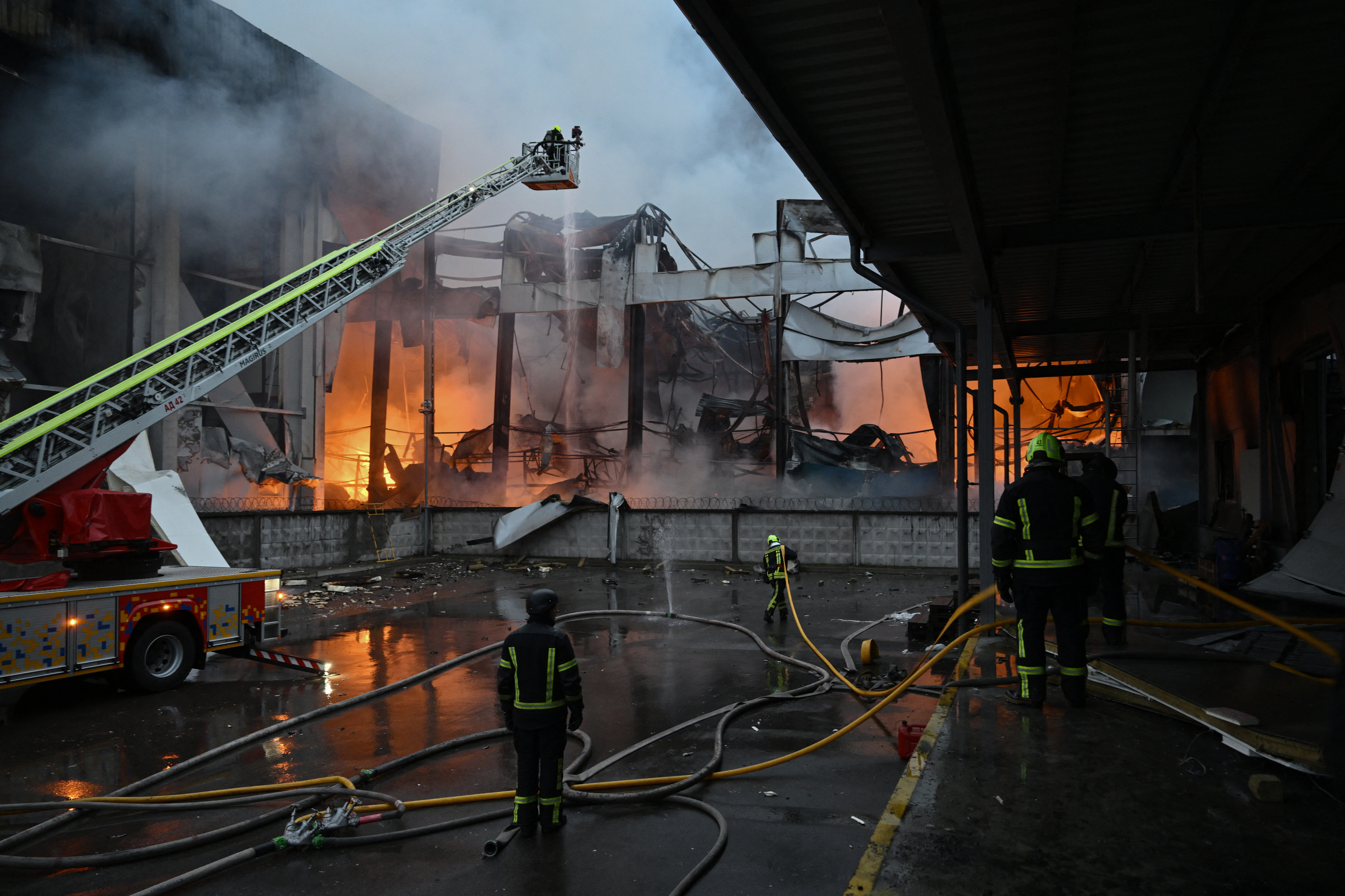 Ukrainian firefighters extinguish a fire at the site of a food warehouse following a Russian missile strike in Kyiv early on October 25, 2025, amid the Russian invasion of Ukraine. (Photo by Genya SAVILOV / AFP)