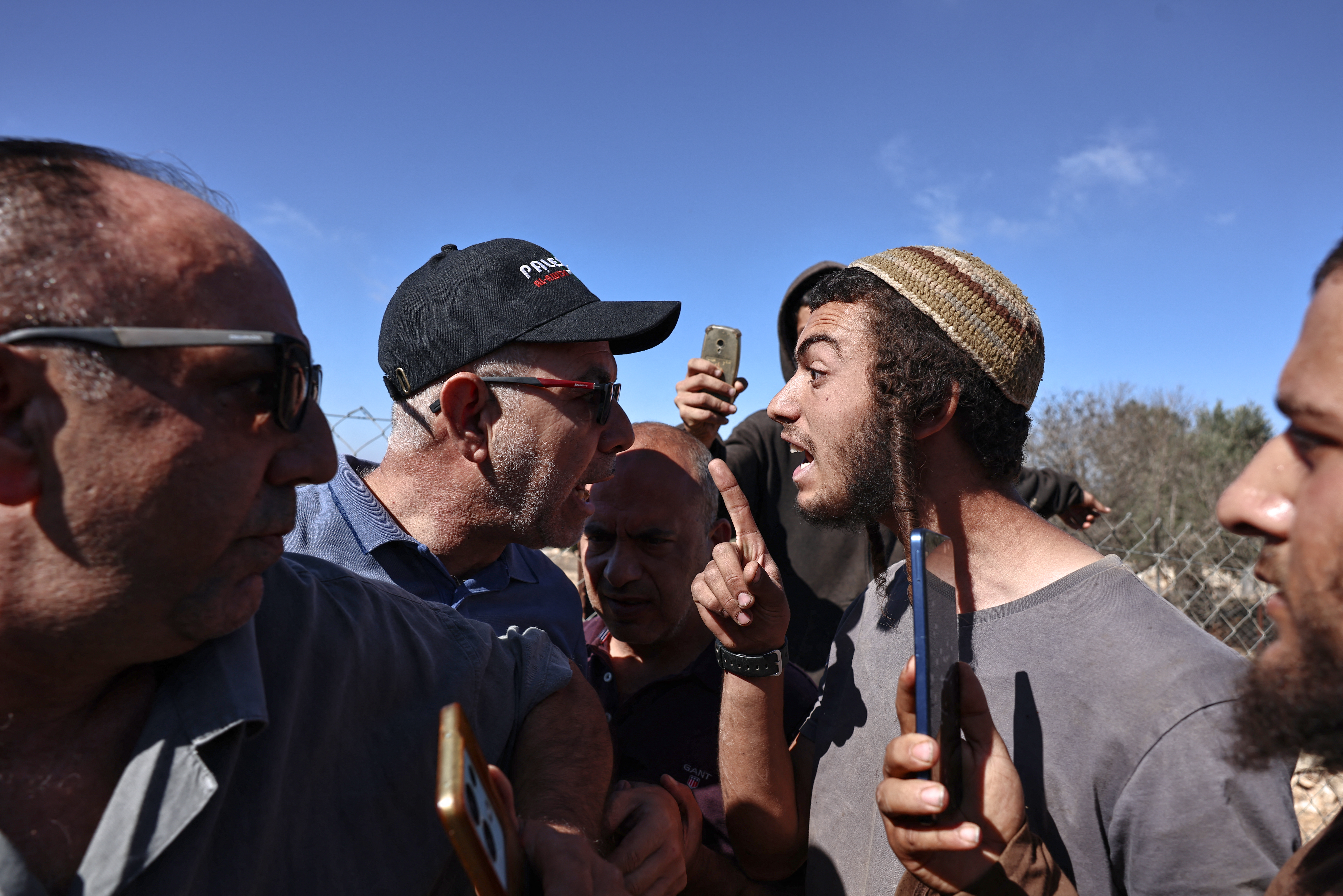 Palestinian farmers (L) scuffle with Israeli settlers during the olive harvest in the Palestinian village of Silwad, near Ramallah in the occupied West Bank