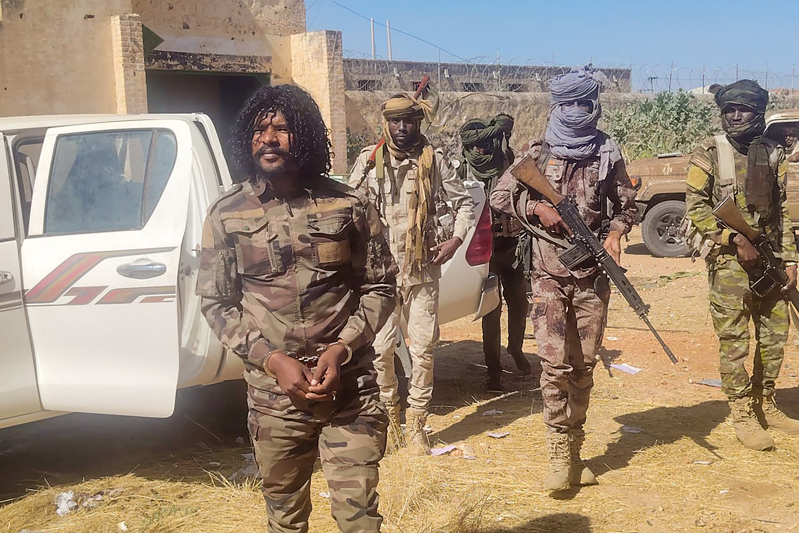 TOPSHOT - This handout picture released by the Sudanese Rapid Support Forces (RSF) on October 30, 2025, shows RSF members reportedly detaining a fighter known as Abu Lulu (L) in El-Fasher, in war-torn Sudan’s western Darfur region.