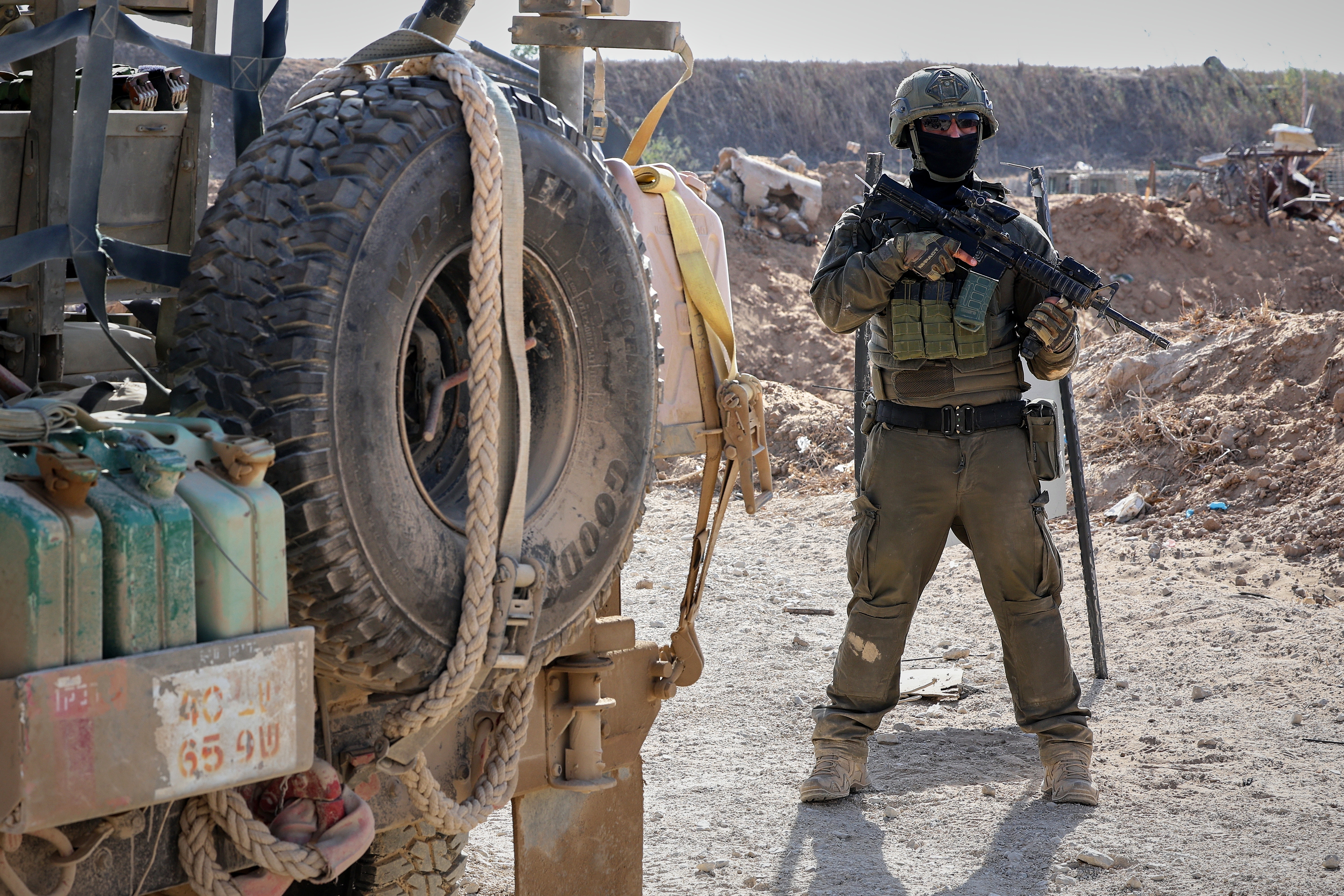 This picture taken during a media tour organised by the Israeli army shows an Israeli army soldier standing next to a military jeep in Gaza City, Friday, Oct. 3, 2025. (Jack Guez/Pool Photo via AP)