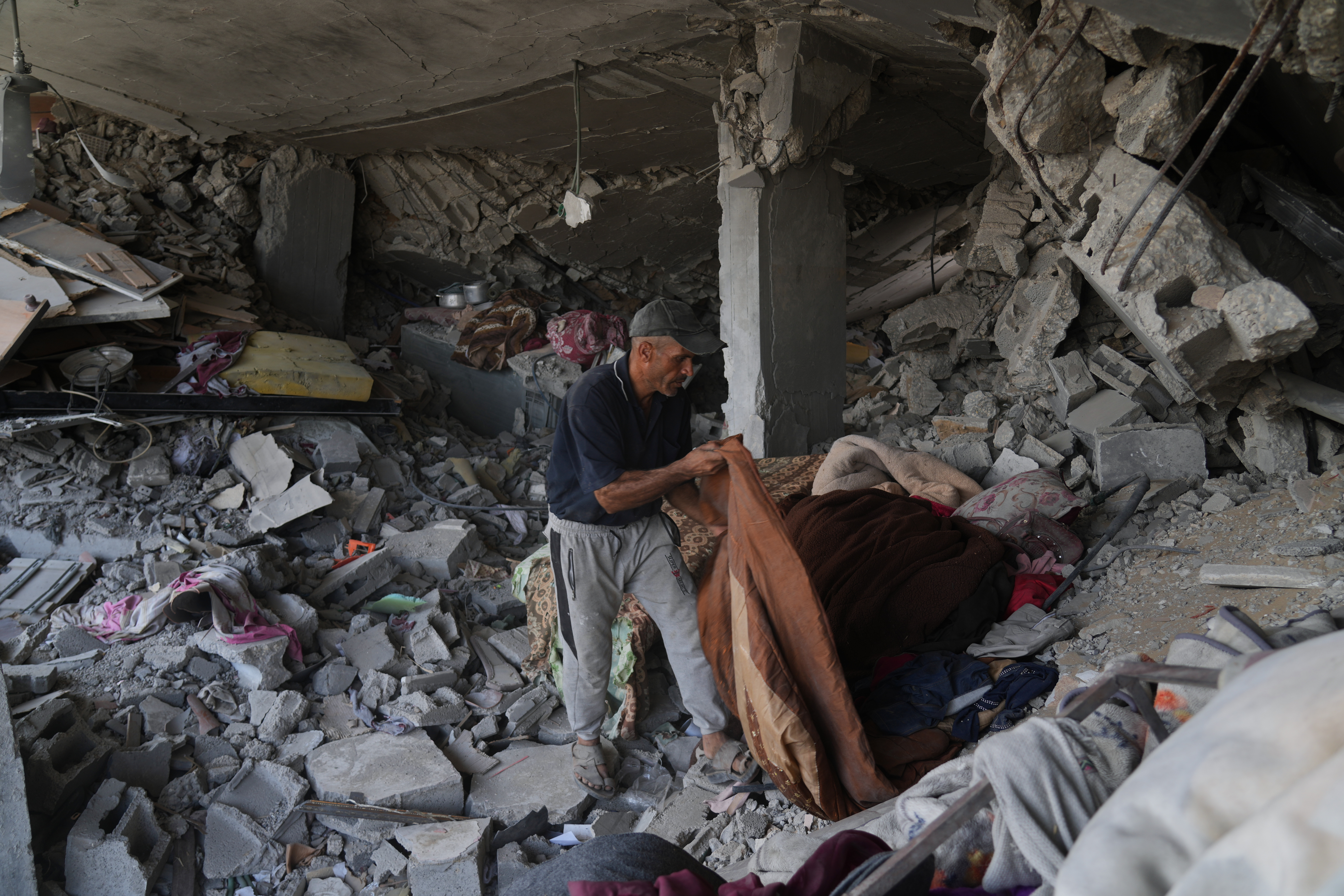 Kamal al-Yaziji, 50, sorts through the rubble of his three-story home destroyed in the war between Israel and Hamas, in the al-Nafaq area of the Sheikh Radwan neighborhood, in Gaza City, Friday, Oct. 24, 2025. (AP Photo/Abdel Kareem Hana)