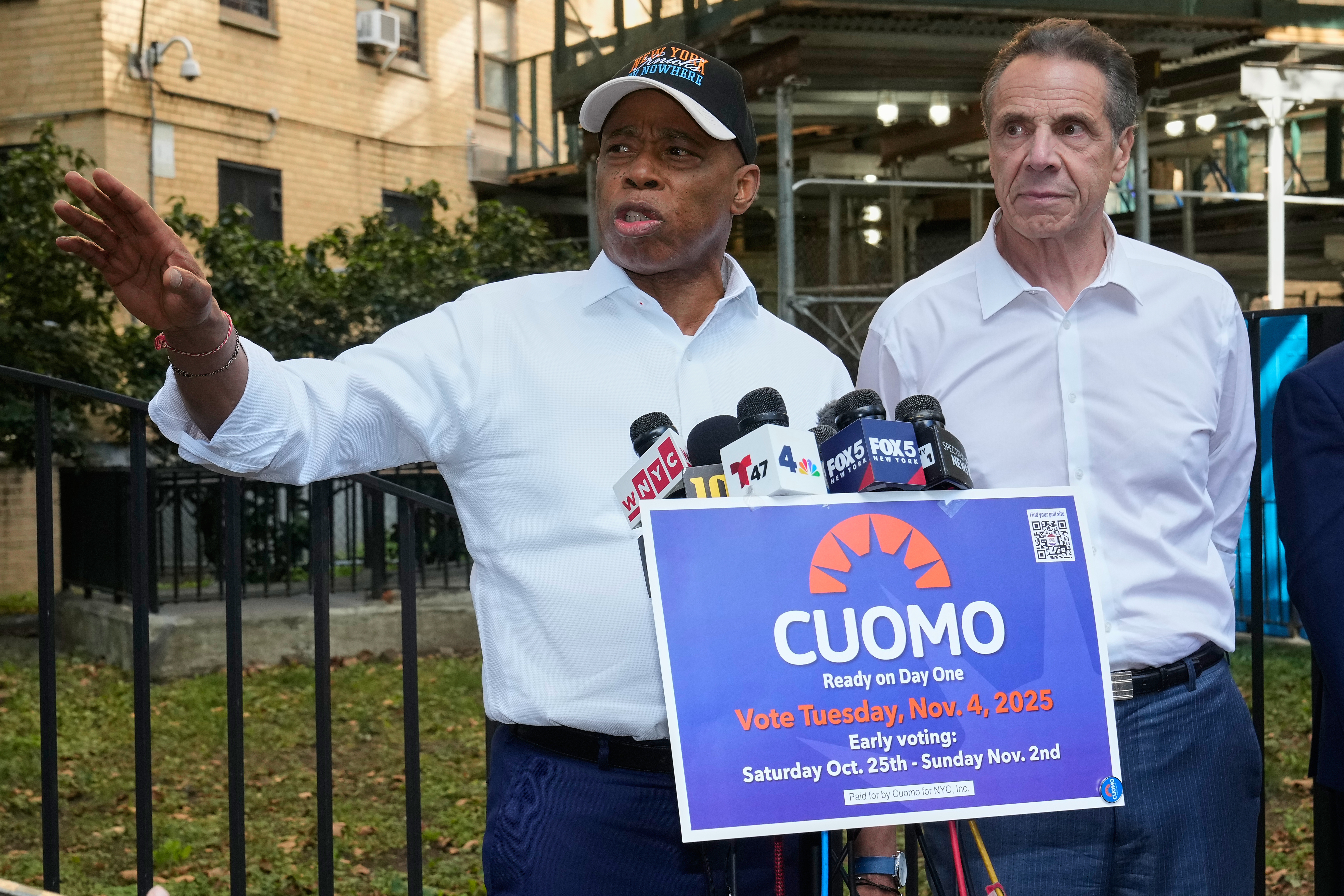New York Mayor Eric Adams, left, and Democrat mayoral candidate Andrew Cuomo appear at a campaign event outside the George Washington Carver Houses, in New York, Thursday, Oct. 23, 2025. (AP Photo/Richard Drew)
