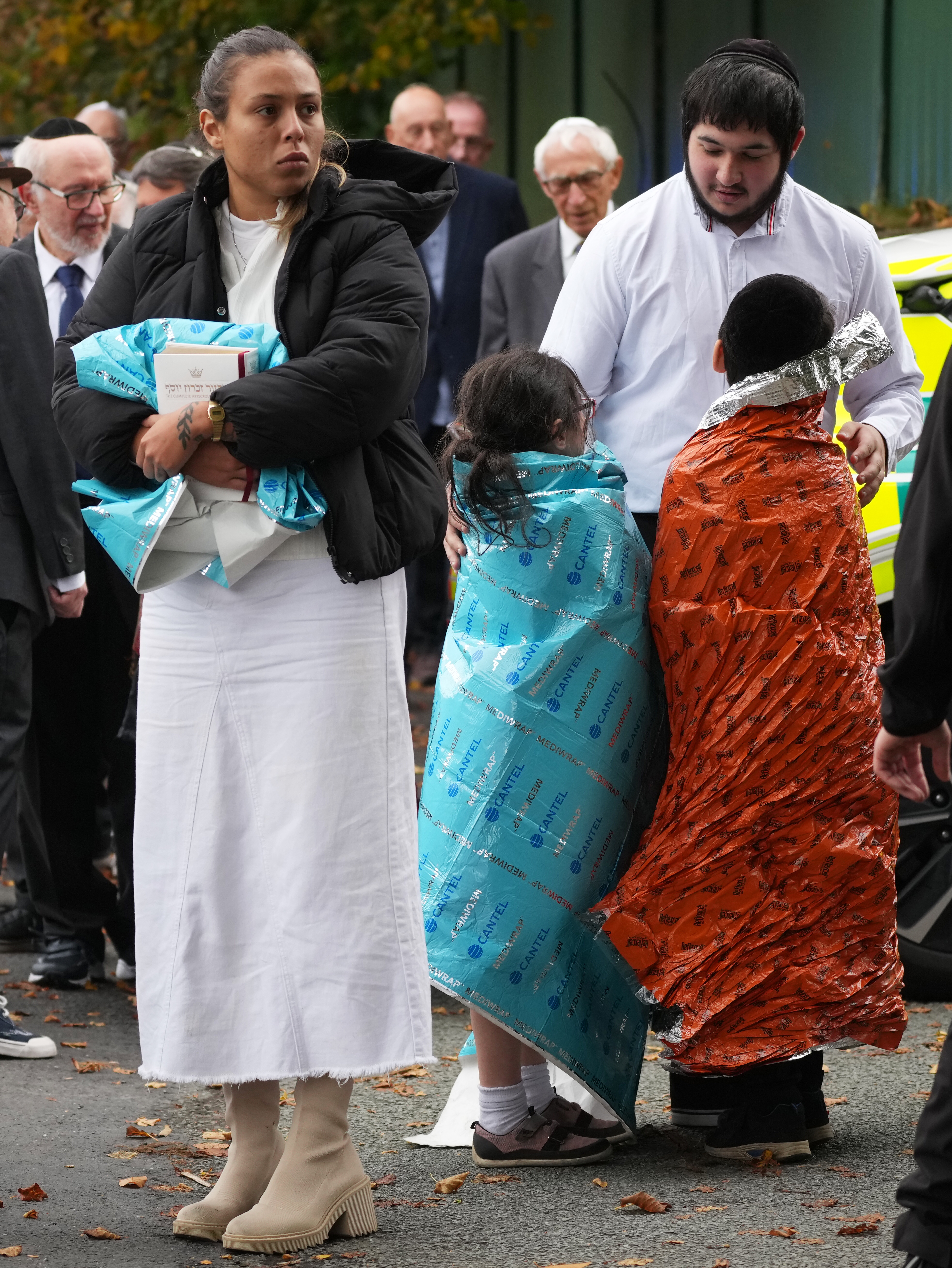 MANCHESTER, ENGLAND - OCTOBER 2: Members of the public and congregants seen as Police and other emergency responders attend the Heaton Park Hebrew Congregation Synagogue, where multiple were injured after stabbing and car attack on Yom Kippur, on October 2, 2025 in the Crumpsall suburb of Manchester, England. Greater Manchester Police said they were called to the scene shortly after 9:30 AM, when a witness said the assailant drove a car at people and then stabbed someone. Police then shot the suspected attacker. (Photo by Christopher Furlong/Getty Images)