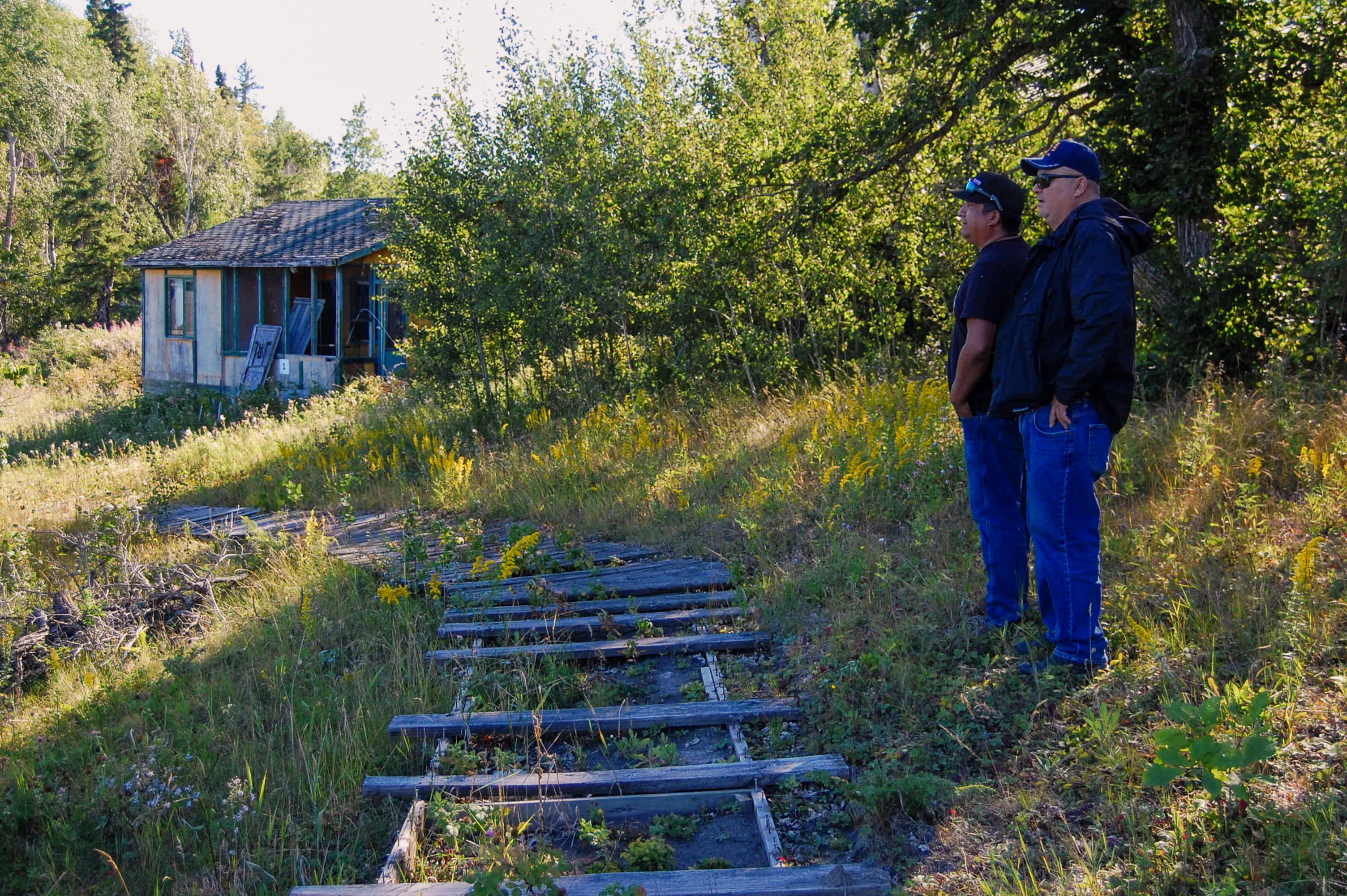 Mike and JB Fobister look out onto the water from a hilltop at what was previously the Grassy Lodge fishing camp