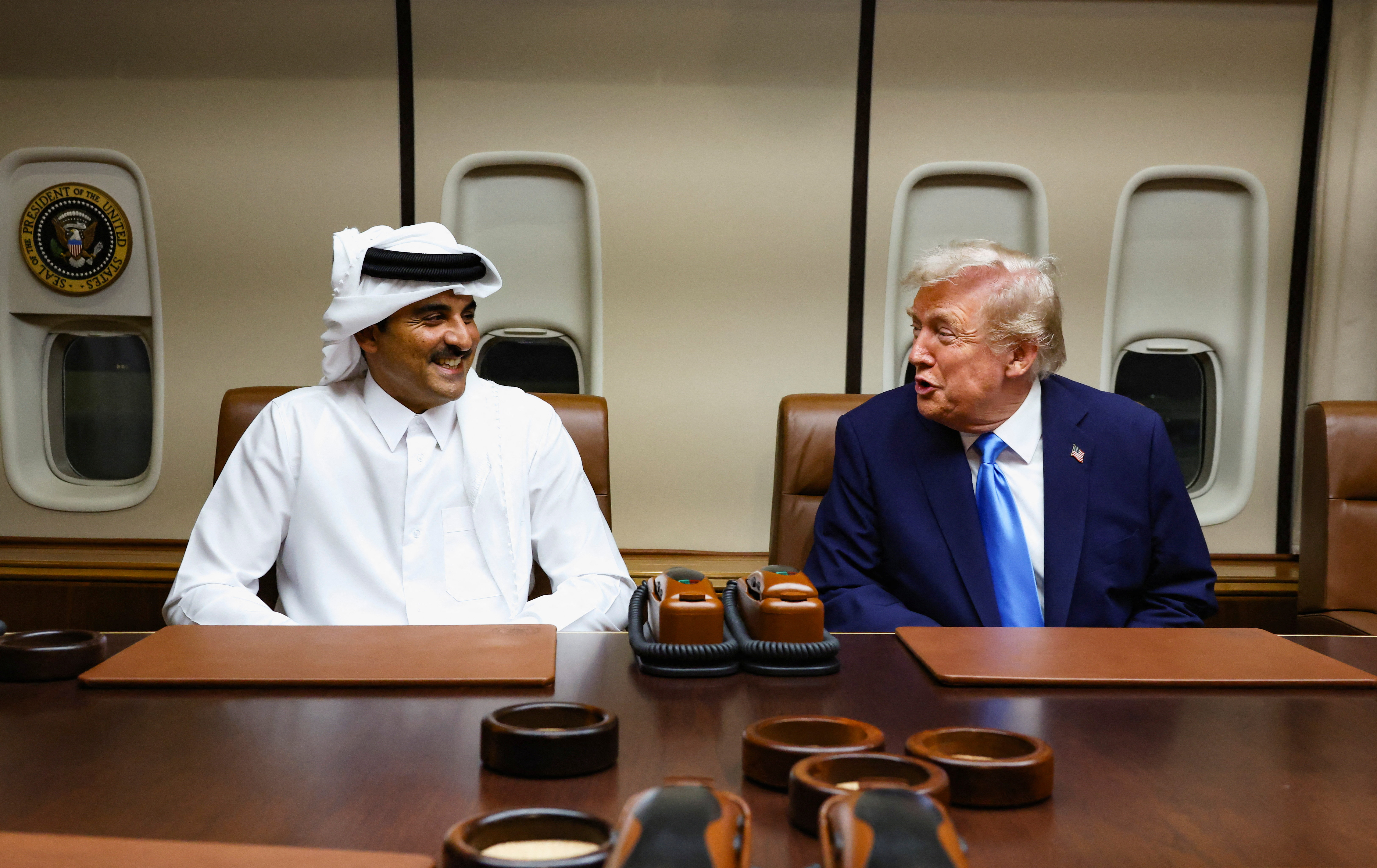 U.S. President Donald Trump speaks with Qatar's Emir Sheikh Tamim bin Hamad Al Thani during a meeting onboard Air Force One during its refuelling stop at Al Udeid Air Base near Doha, Qatar, October 25, 2025. REUTERS/Evelyn Hockstein