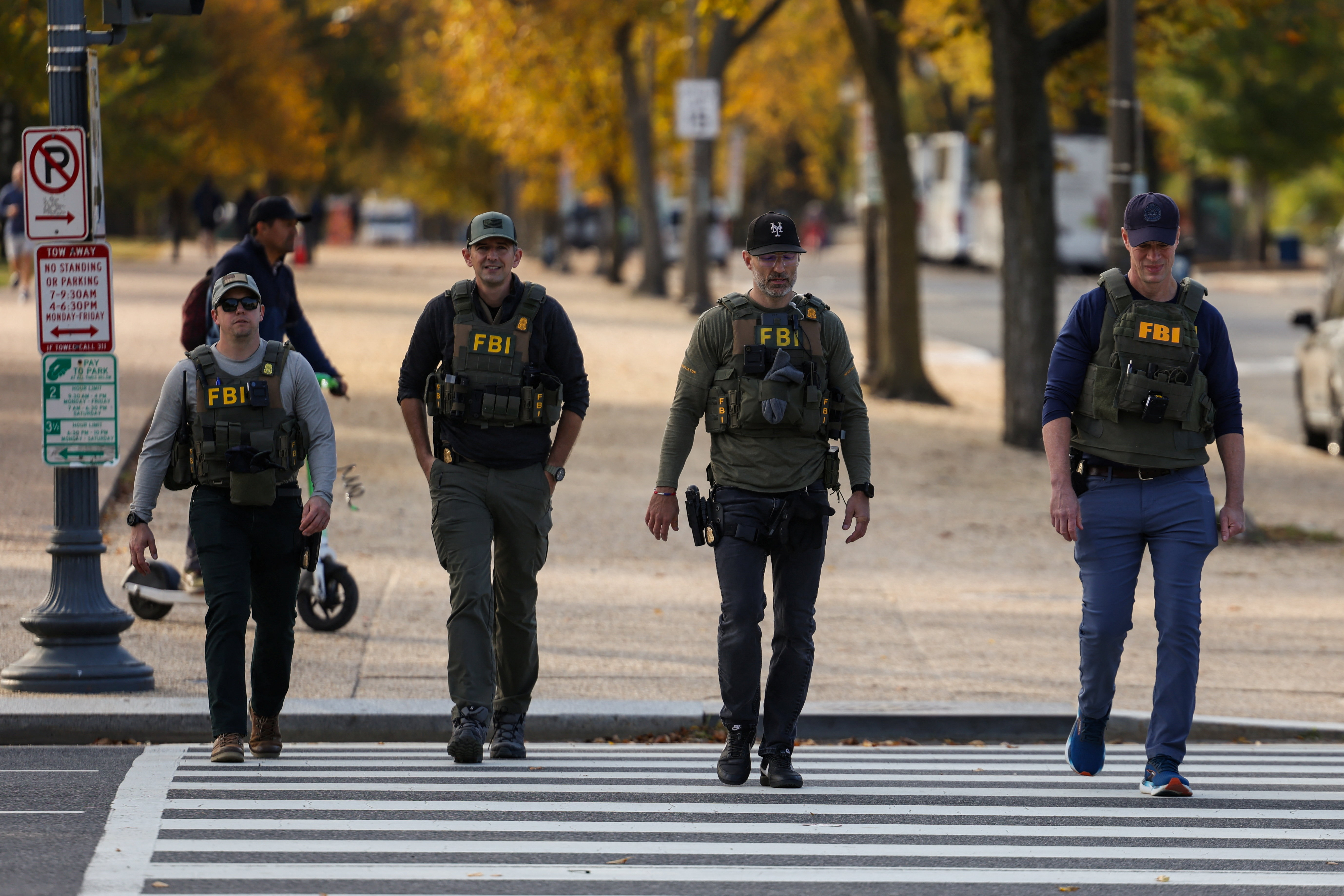Members of the U.S. Federal Bureau of Investigation (FBI) walk along the National Mall, weeks into the continuing U.S. government shutdown, in Washington, D.C., U.S., October 27, 2025. REUTERS/Kylie Cooper