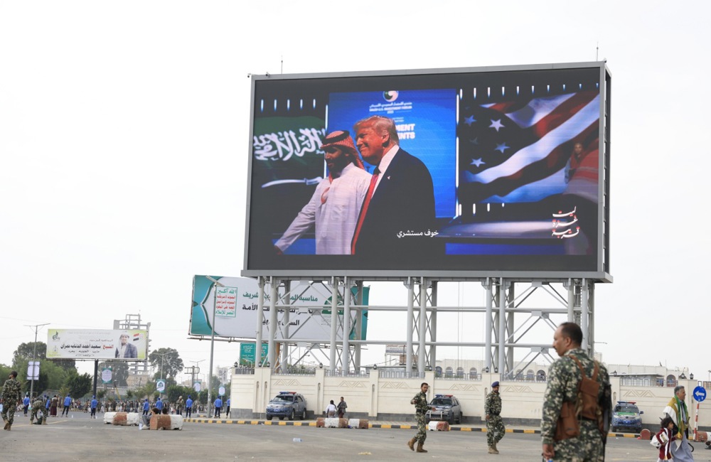 epa12317044 Houthi soldiers stand guard in front of a digital billboard featuring US President Donald Trump (R) and Saudi Crown Prince Mohammed bin Salman (L), during a protest in support of the Palestinian people, in Sana'a, Yemen, 22 August 2025. Thousands of Houthis protested in Sana'a in support of the Palestinian people and against Israel's military campaign in the Gaza Strip. EPA/YAHYA ARHAB