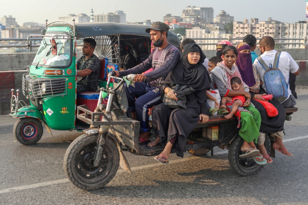 a family on a three wheeled motorcycle next to a tuk tuk