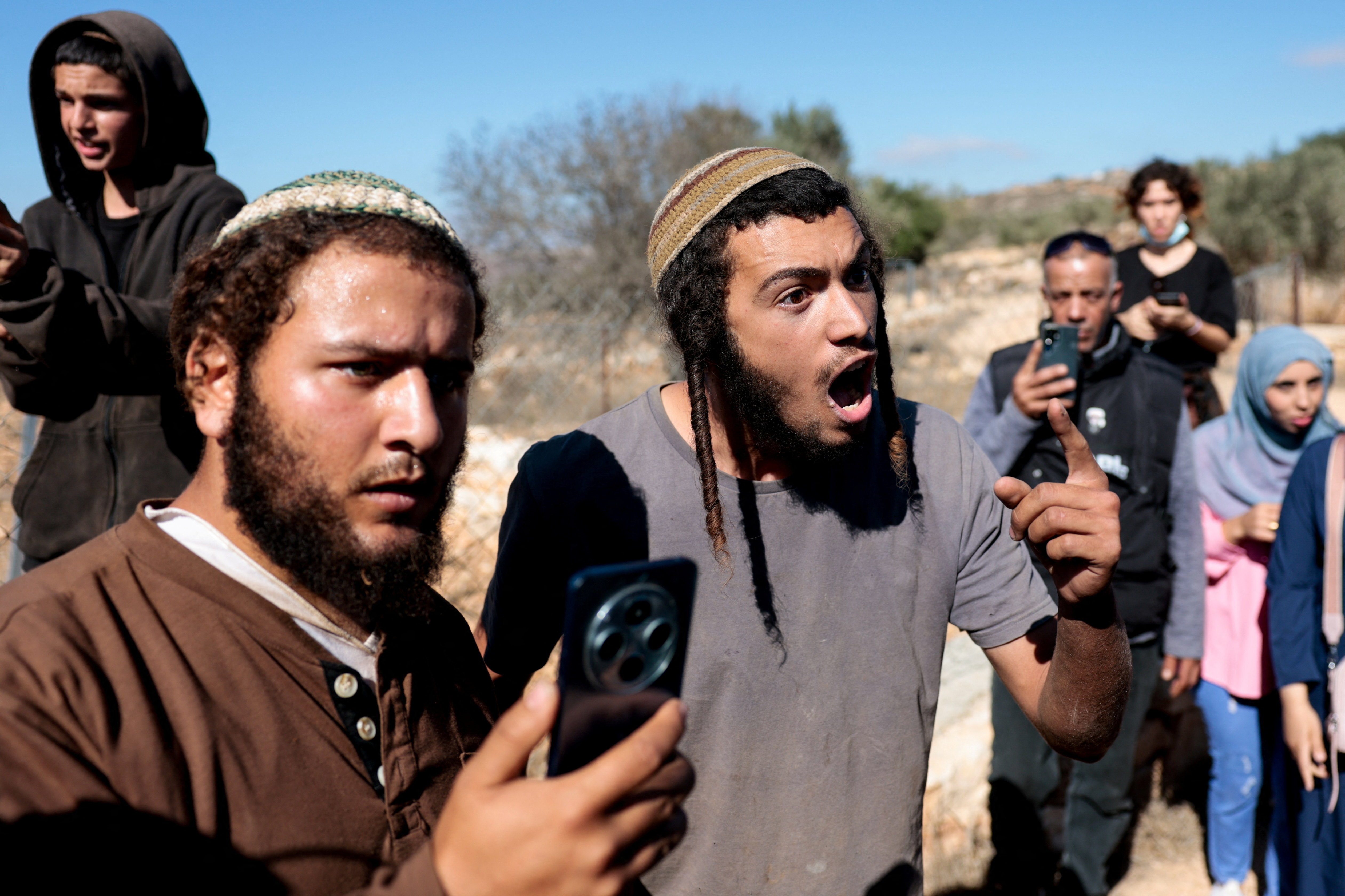 An Israeli settler gestures as he argues with a Palestinian farmer (not pictured), during olive harvesting in Silwad, near Ramallah, in the Israeli-occupied West Bank, October 29, 2025. REUTERS/Mohammed Torokman
