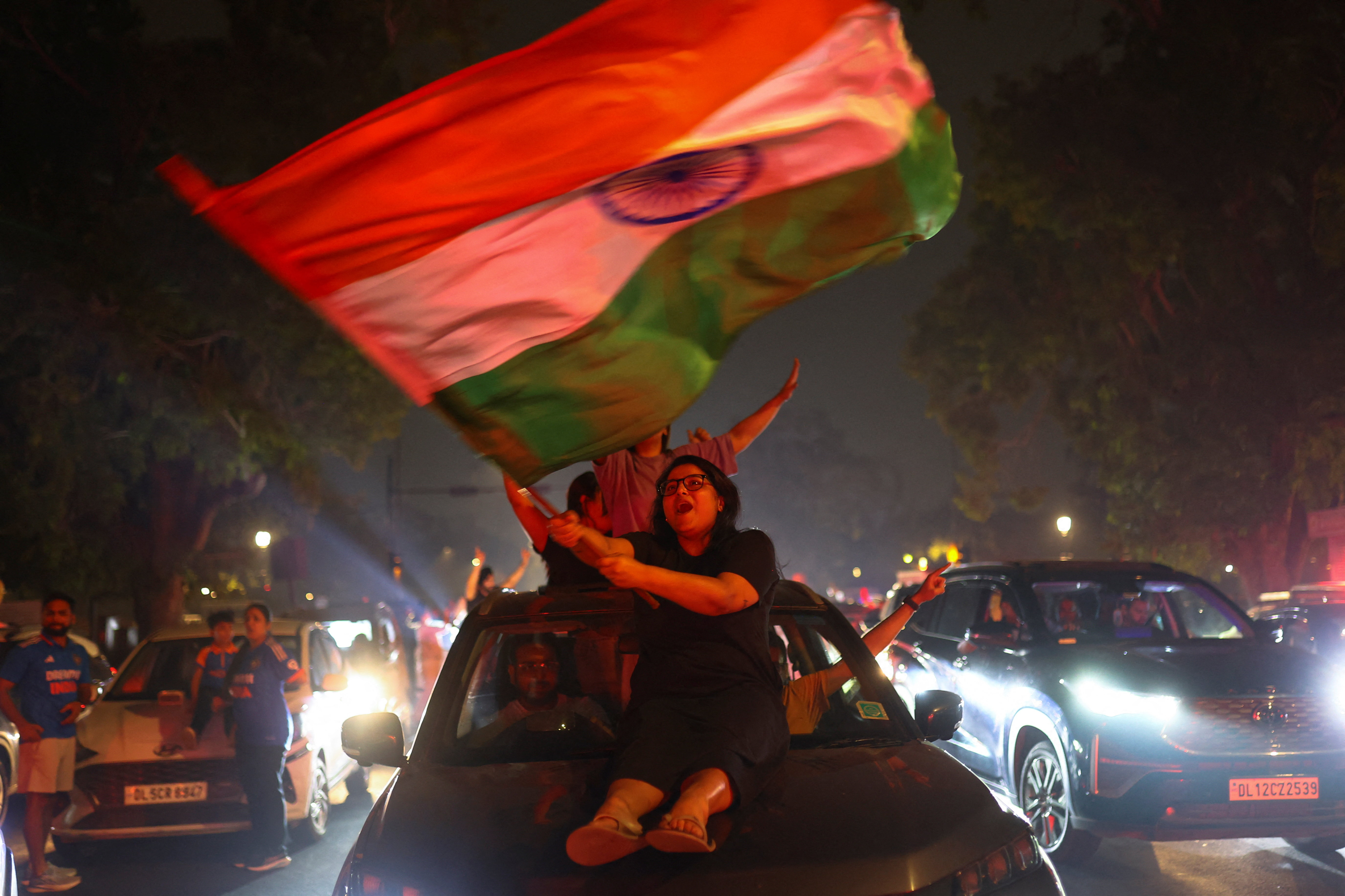 A woman waves a flag as India's cricket fans celebrate.