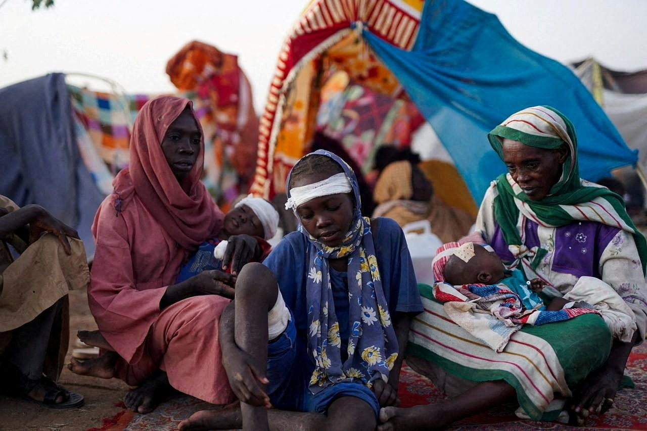 Ikram Abdelhameed looks on next to her family, North Darfur, Sudan