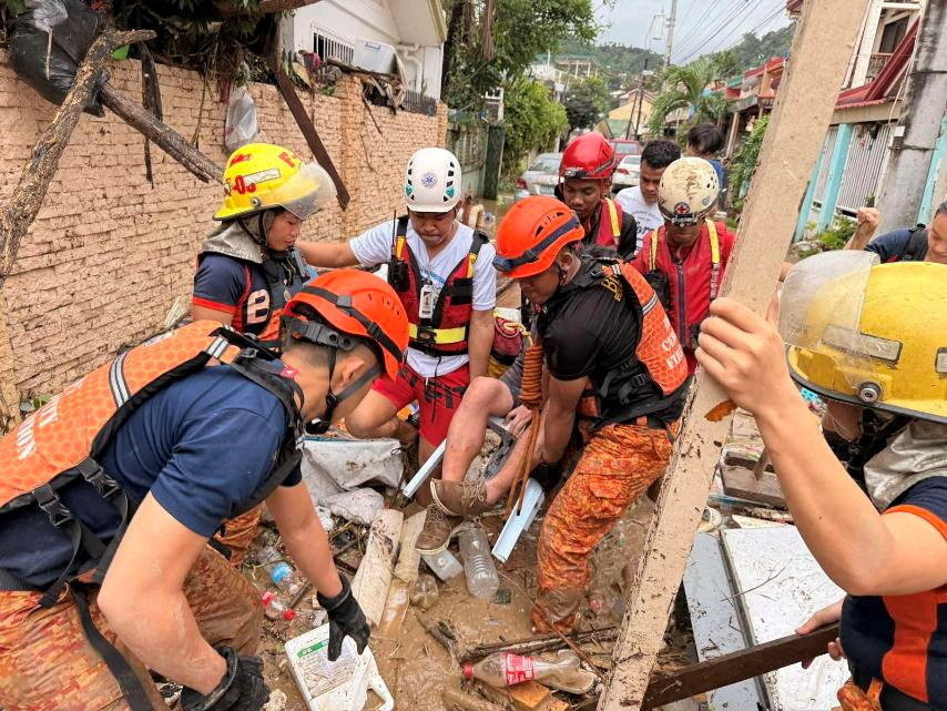 Philippine Red Cross personnel rescue a resident following torrential rains brought by Typhoon Kalmaegi [Philippine Red Cross/Handout via REUTERS]