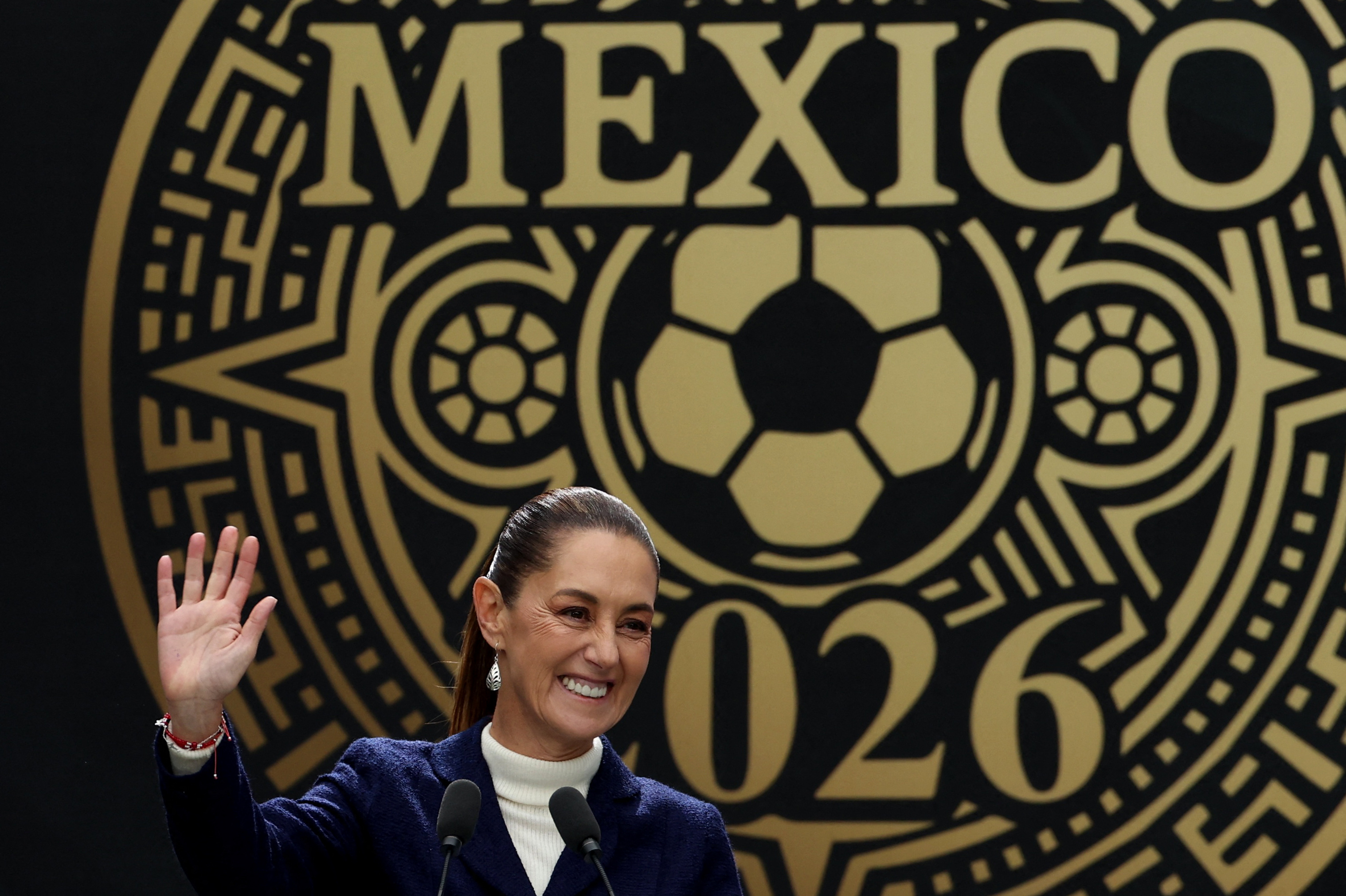 Claudia Sheinbaum in front of a Mexico 2026 sign