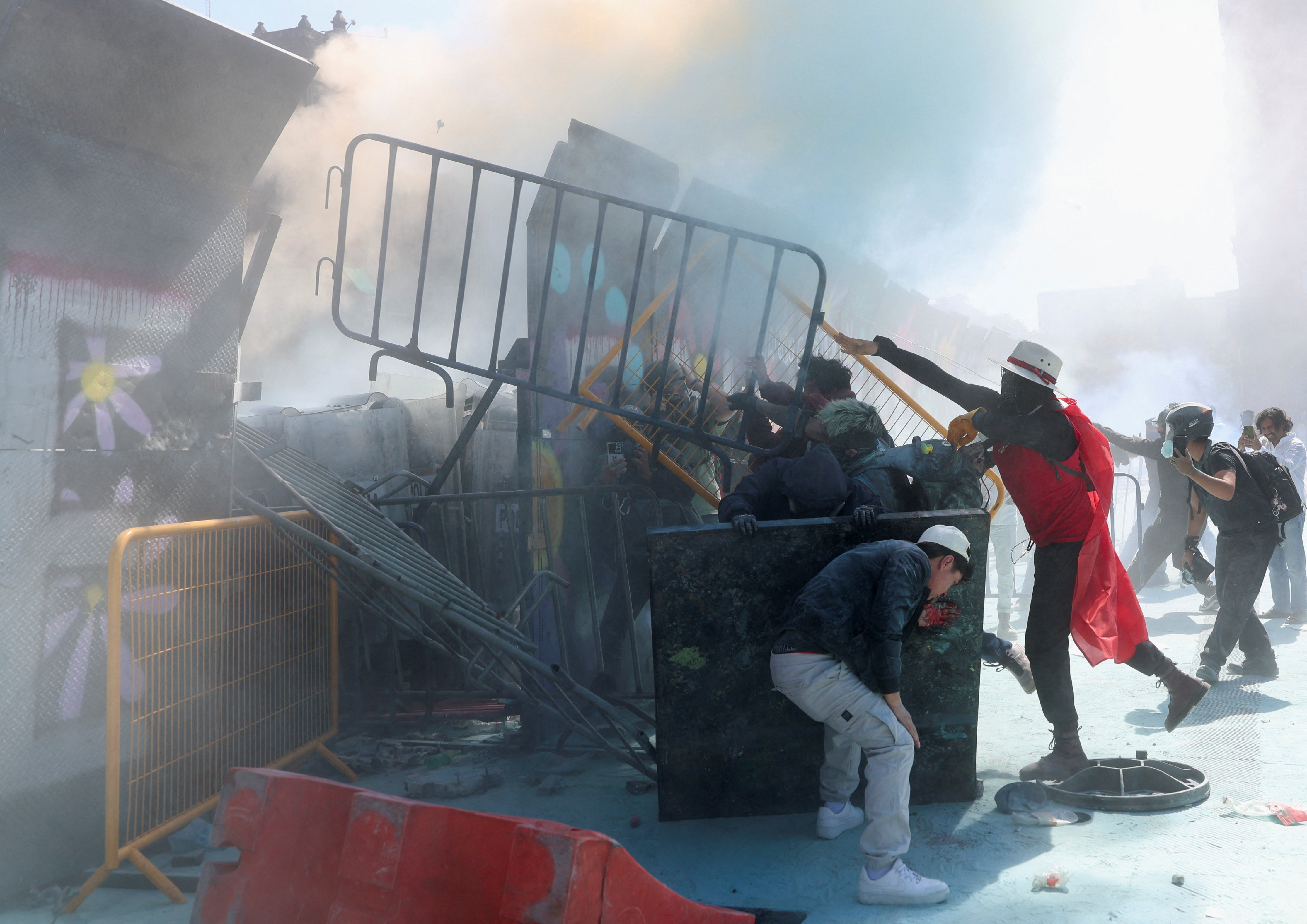 Demonstrators dismantle parts of a barrier protecting the National Palace during a protest against insecurity and corruption in the country, in the Zocalo square, in Mexico City, Mexico, November 15, 2025.