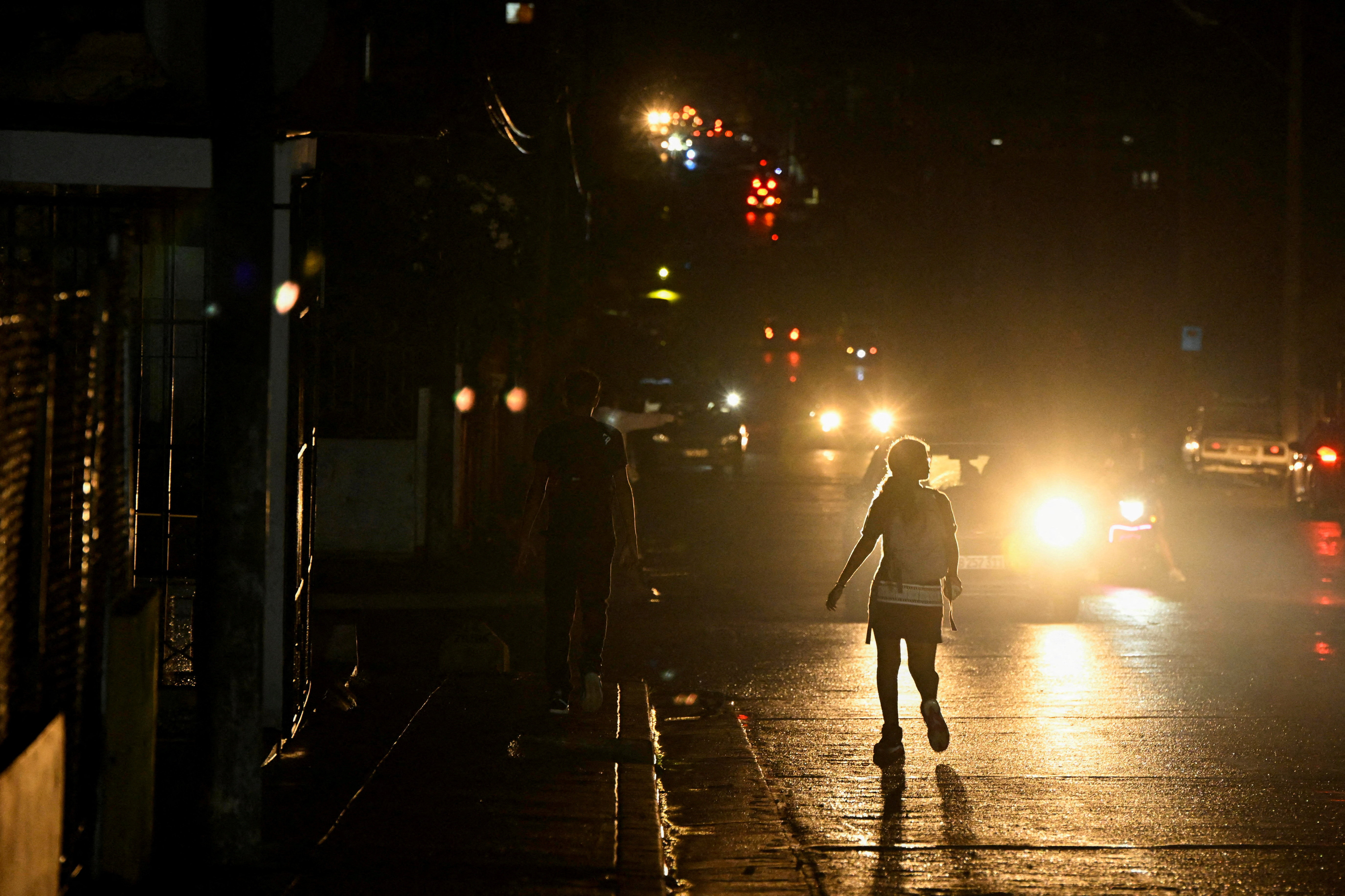 People walk on the street during a blackout as Cuba struggles to ease power cuts amid reduced fuel supplies from Venezuela, in Havana, Cuba, on November 18, 2025 [Norlys&nbsp;Perez/Reuters]