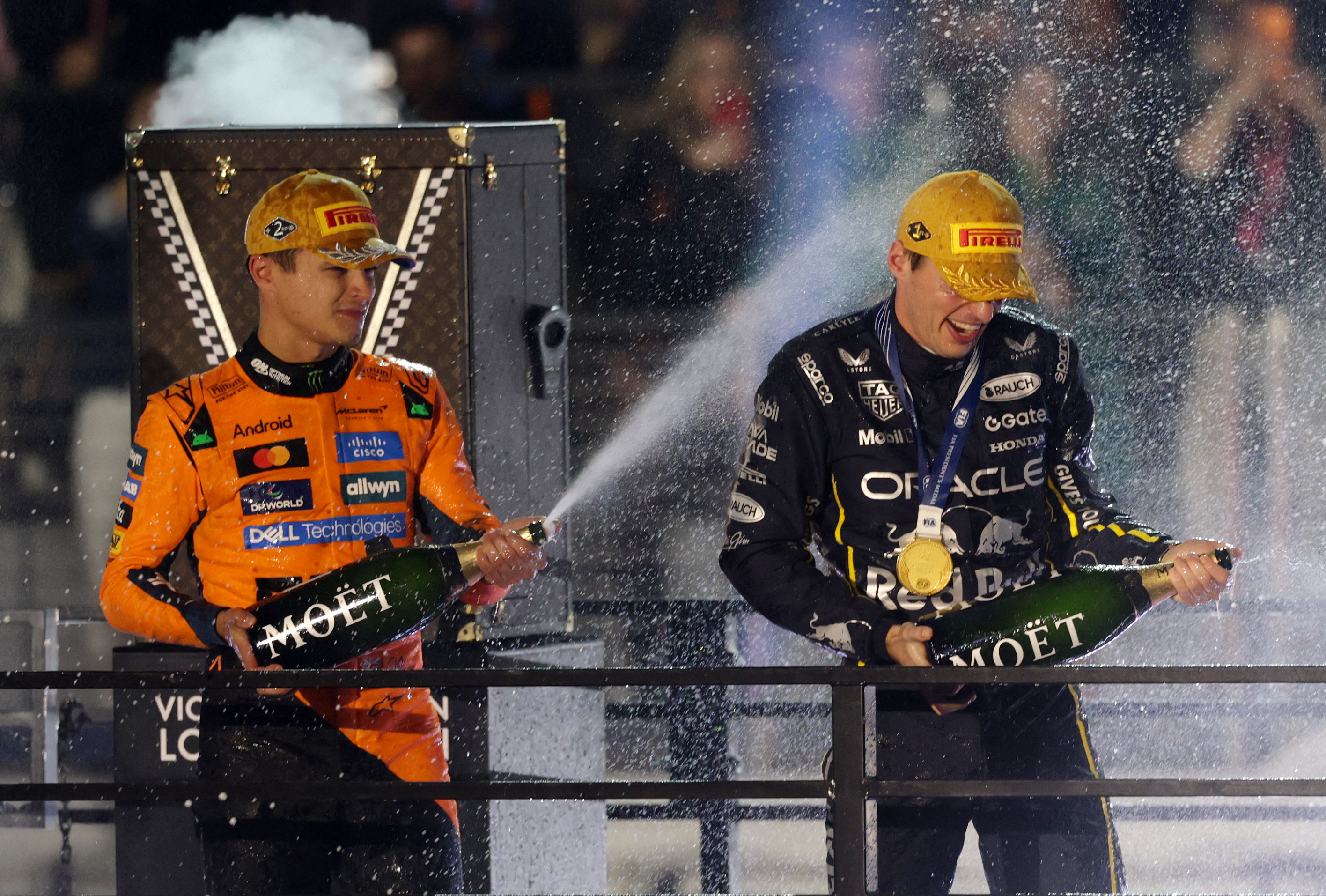 Red Bull's Max Verstappen celebrates on the podium along with second-placed McLaren's Lando Norris.