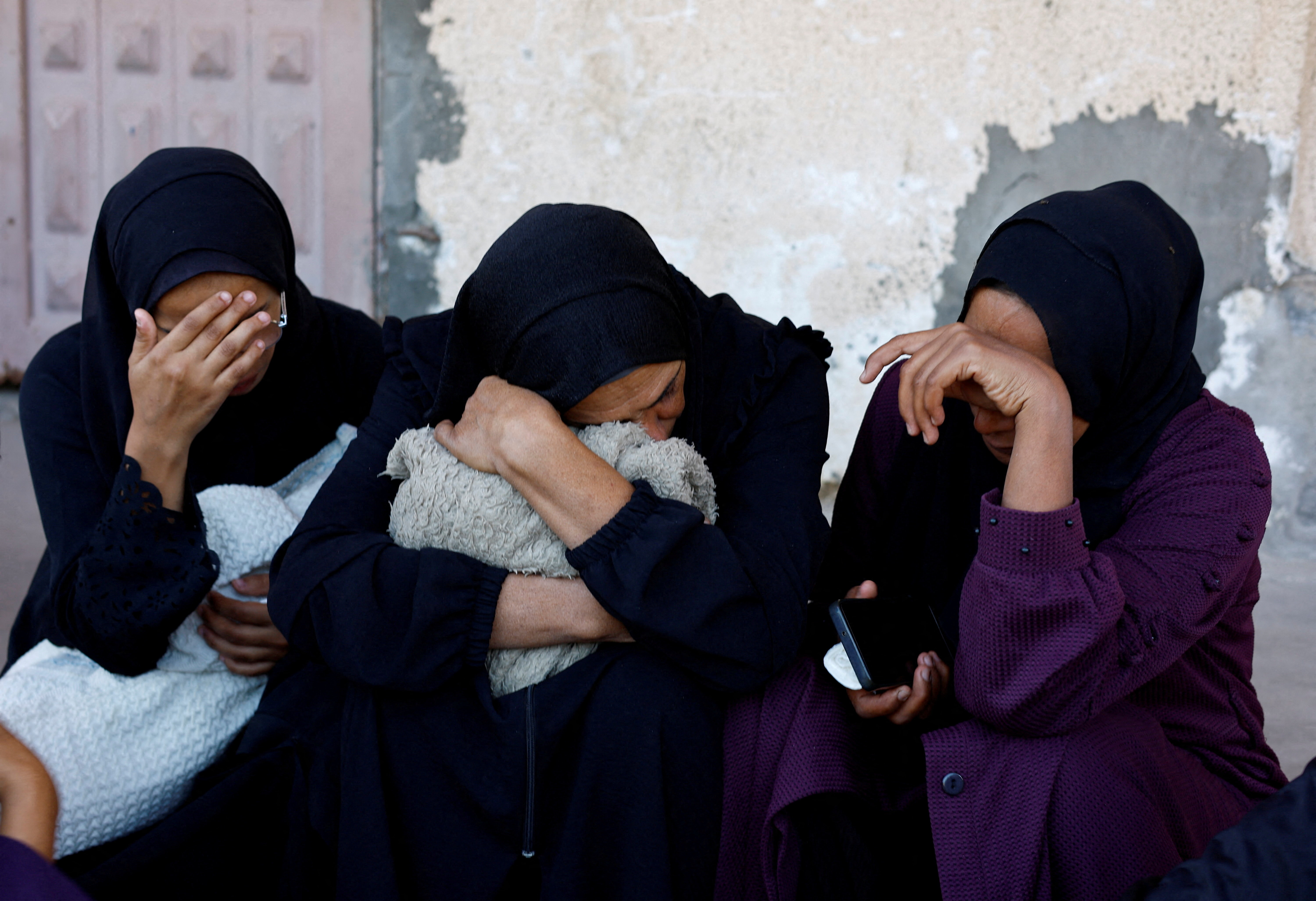 Mourners react as they attend the funeral of Palestinians who, according to medics, were killed in Saturday's Israeli strikes, in Al-Aqsa Martyrs Hospital, in Deir al-Balah, central Gaza Strip, November 23, 2025.