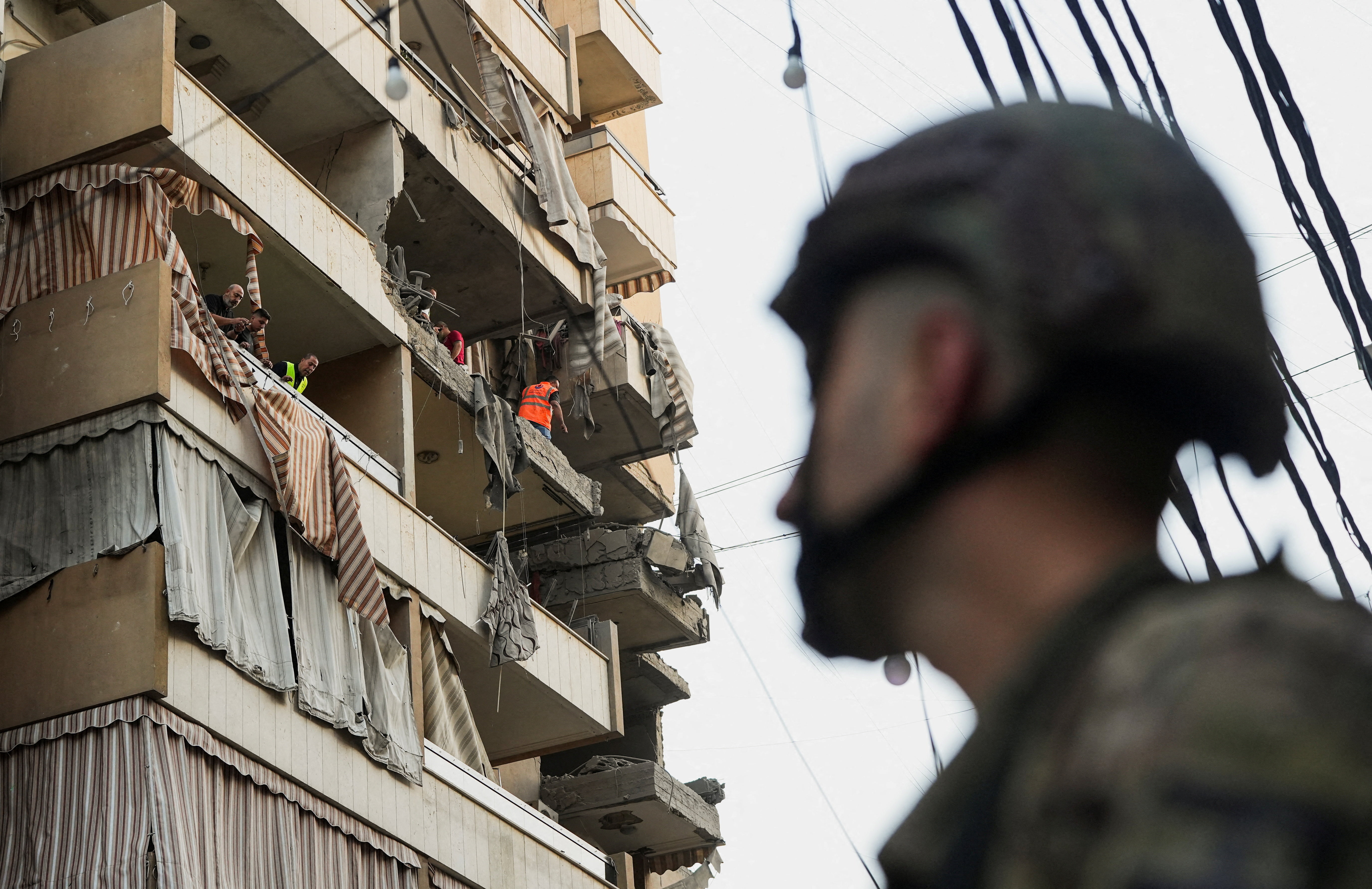 People inspect a damaged building, after Israeli military said on Sunday that it struck a militant from the Lebanese Iran-aligned Hezbollah group, in Beirut's southern suburbs, Lebanon November 23, 2025.