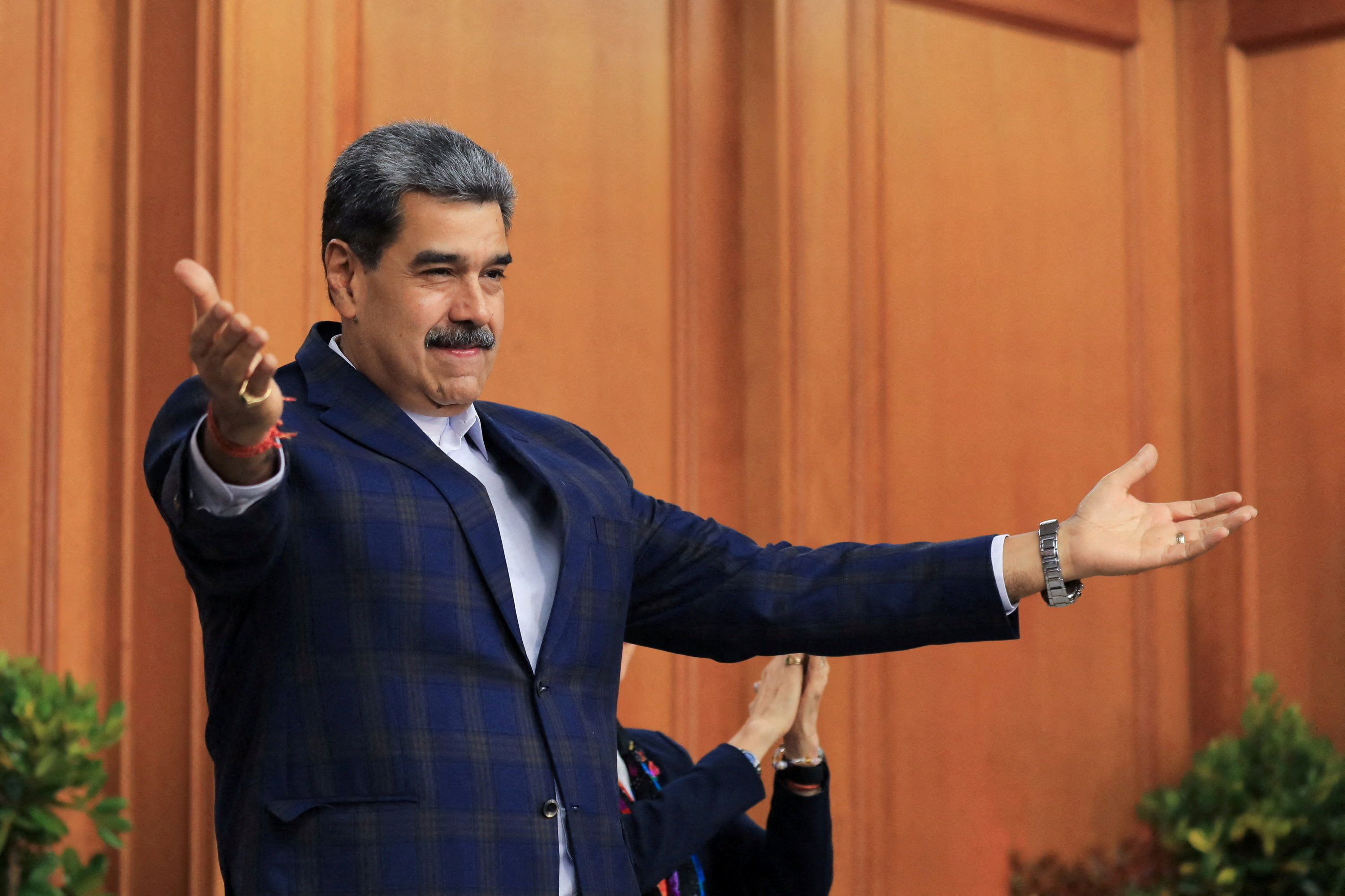Nicolas Maduro, with his arms extended outward