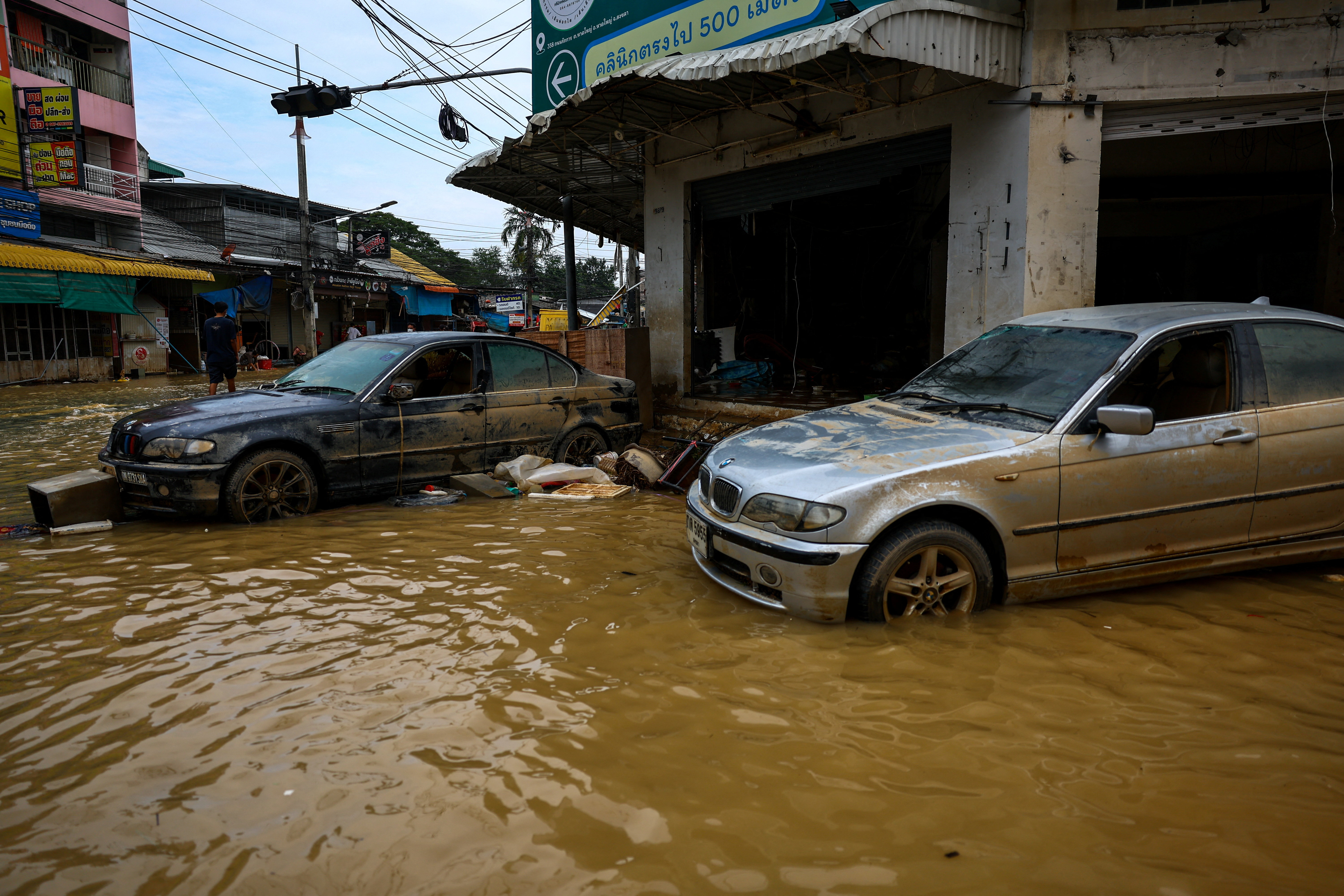 Damaged cars are parked in a flooded area.