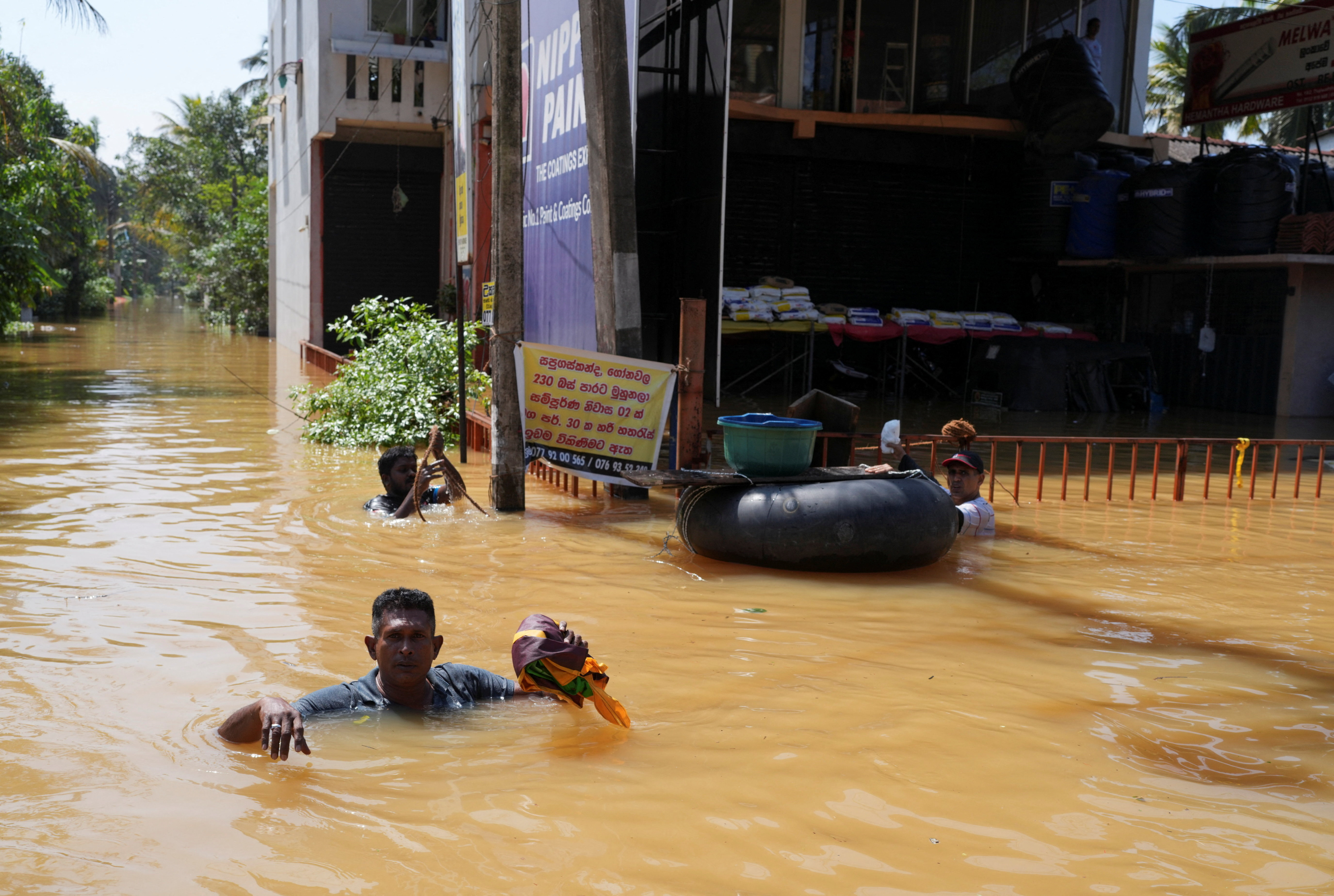 People wade through a flooded street.