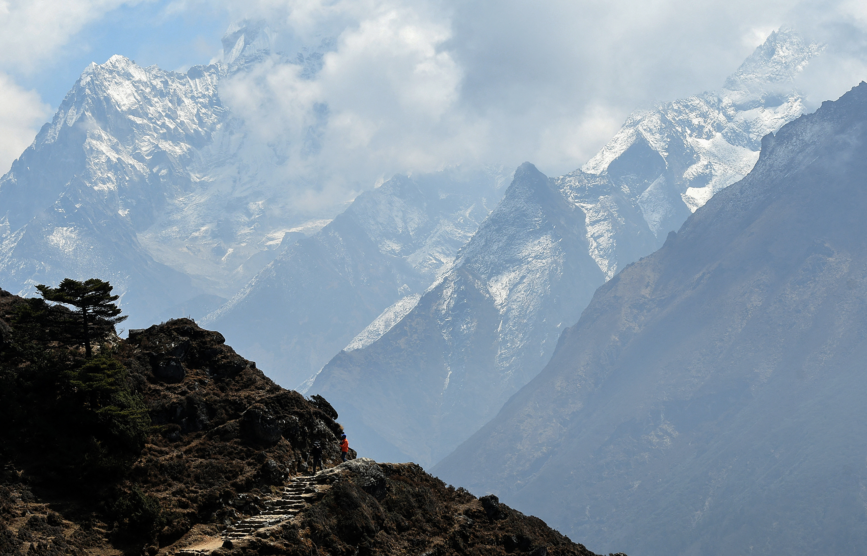 This photo taken on April 16, 2018 shows the trekkers walking along a path at Syangboche in the Everest region, some 140km northeast of Kathmandu. (Photo by PRAKASH MATHEMA / AFP)