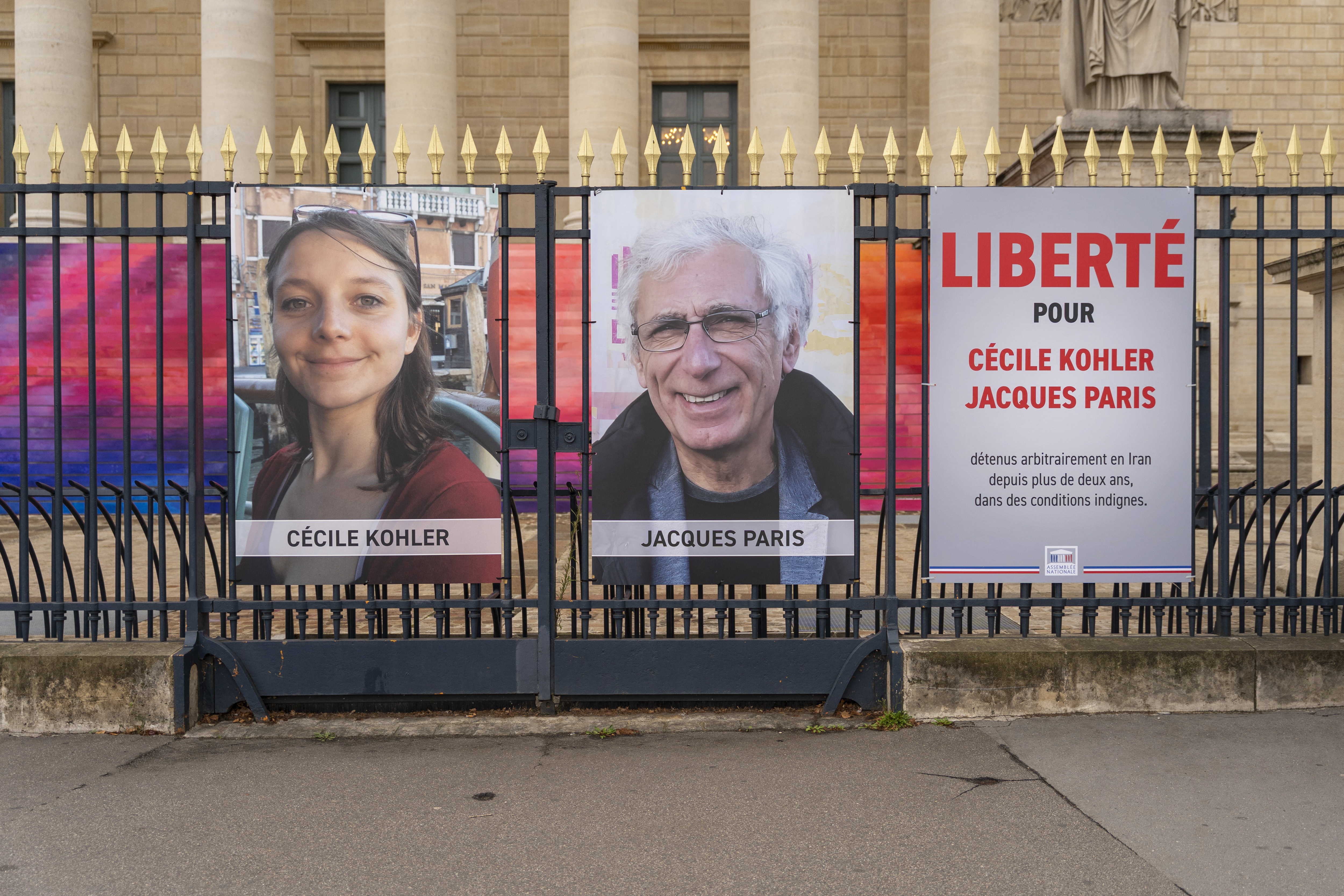 Posters on the gates of the National Assembly demanding the release of Cecile Kohler and Jacques Paris in Paris