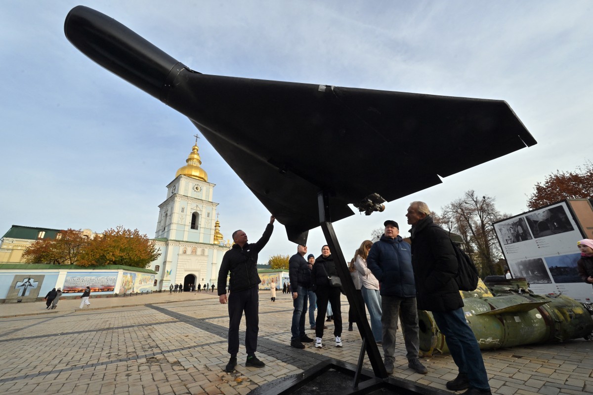 People look at an Iranian-designed Shahed 136, (Geranium-2) drone of Russian Army at an open-air exhibition of destroyed Russian equipment near Saint Michael's Golden-Domed Cathedral in Kyiv on November 2, 2025, amid the Russian invasion of Ukraine. (Photo by Sergei SUPINSKY / AFP)
