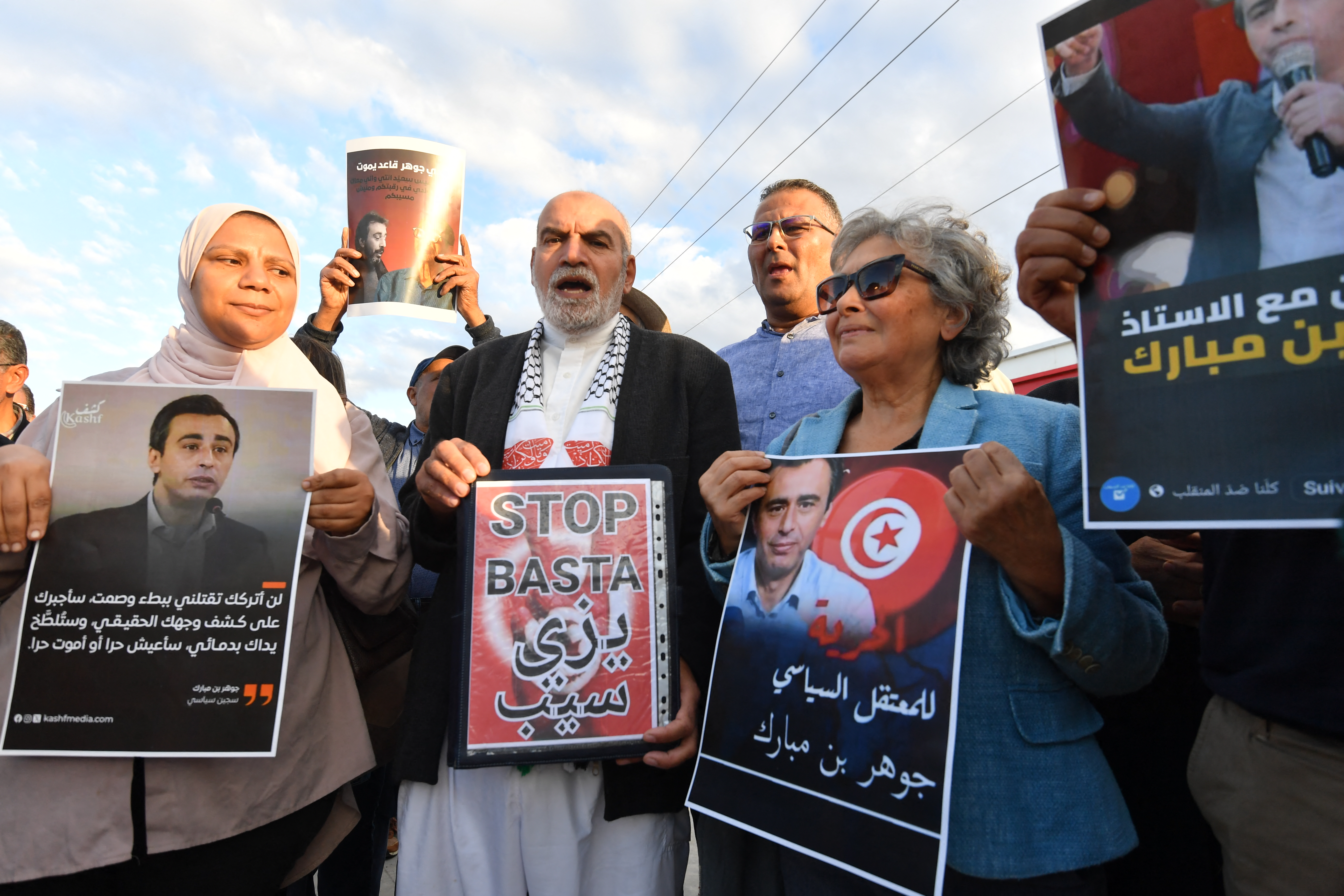Tunisian human rights activist and journalist Sihem Bensedrine (2nd R) holds a portrait of jailed Tunisian opposition figure Jawhar Ben Mbarek during a protest outside the Billi prison in Nabeul on November 7, 2025 to demand his release. Jawhar Ben Mbarek, co-founder of the National Salvation Front opposition alliance, went on hunger strike on October 28 to protest his detention, which began in February 2023. (Photo by FETHI BELAID / AFP)