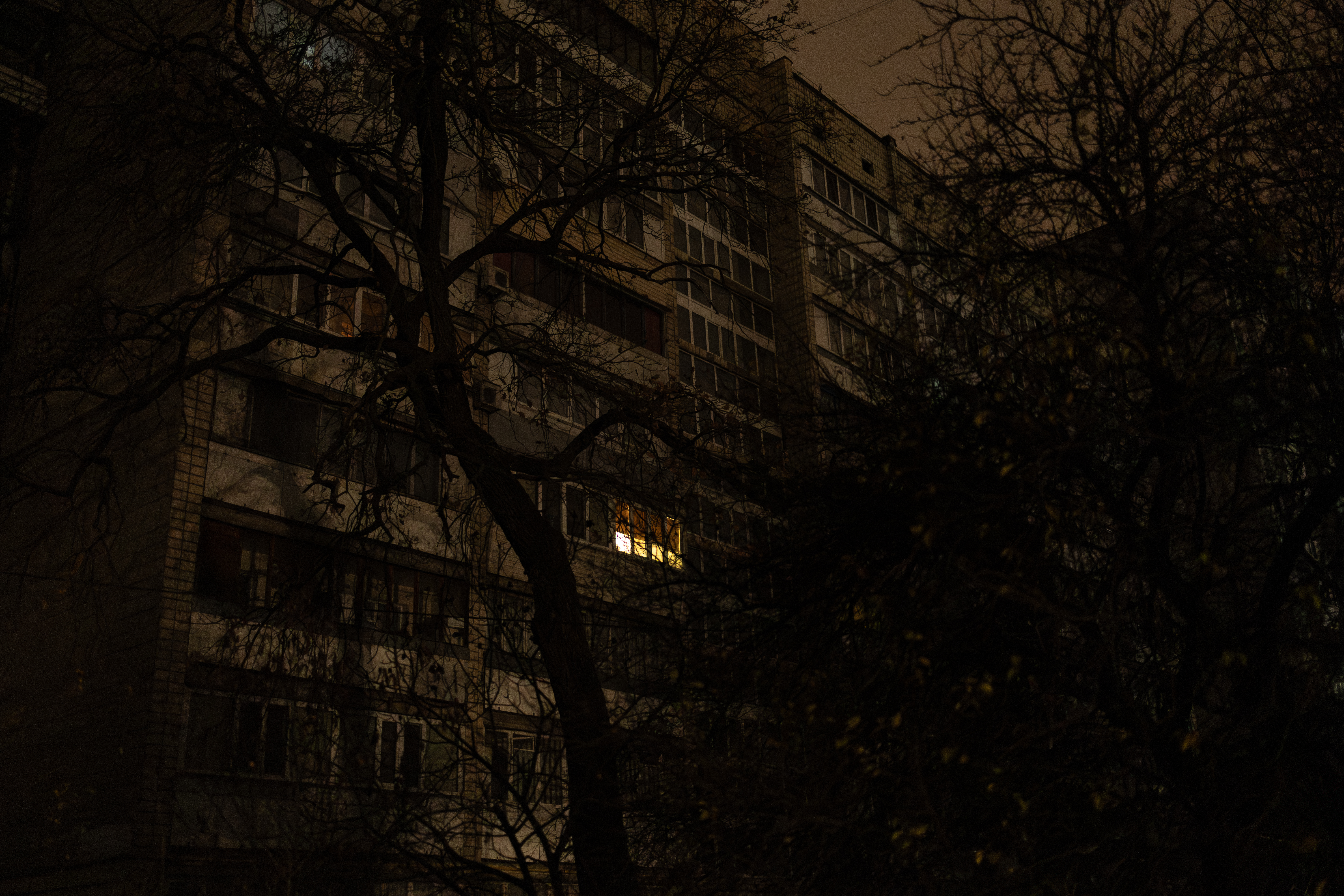 A window with a light on is seen in a residential building during a blackout in Kyiv on November 9, 2025, following Russian missile and drone attacks on Ukrainian energy infrastructure.