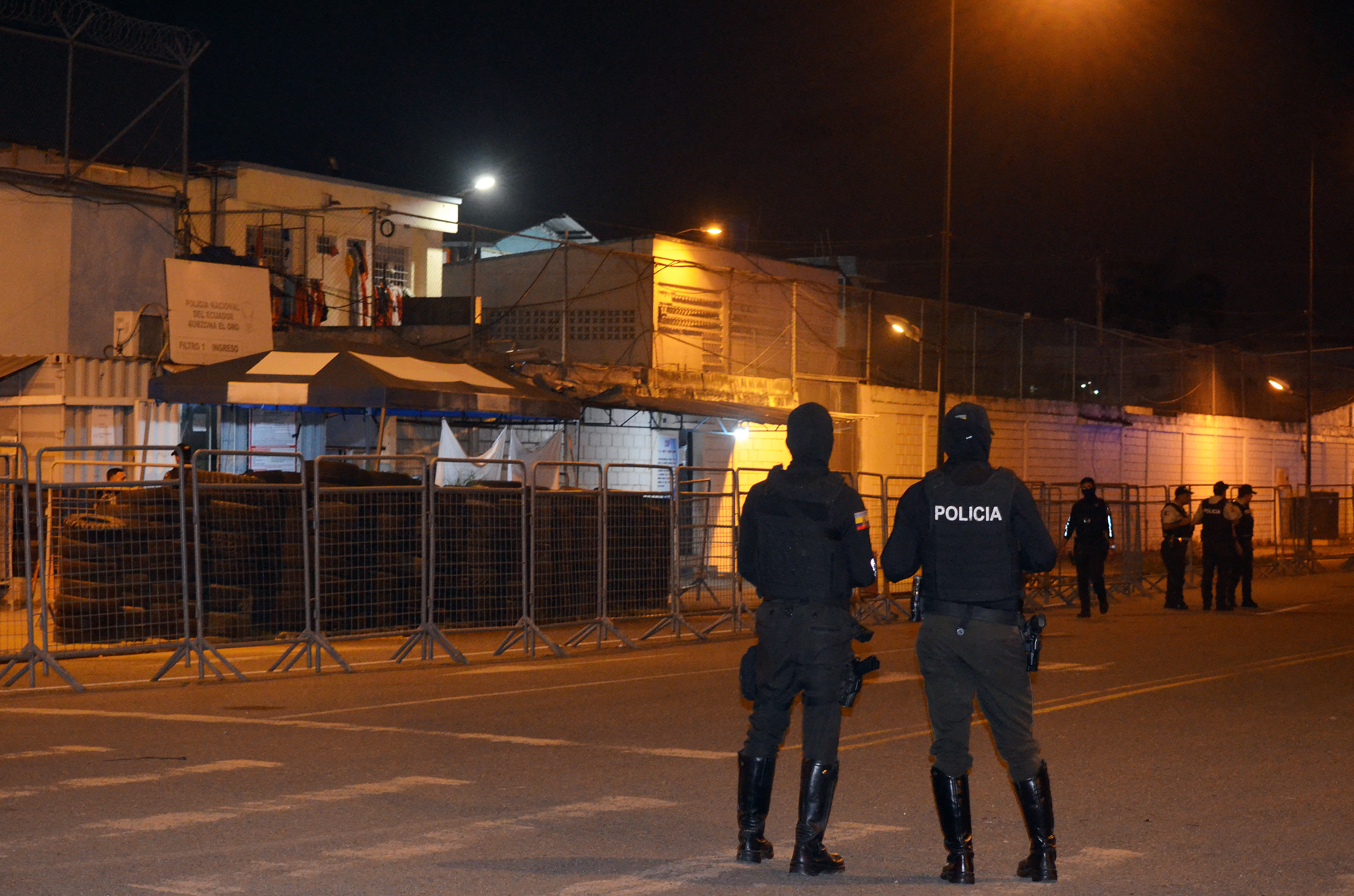 Police officers stand guard at the entrance to the Machala prison.