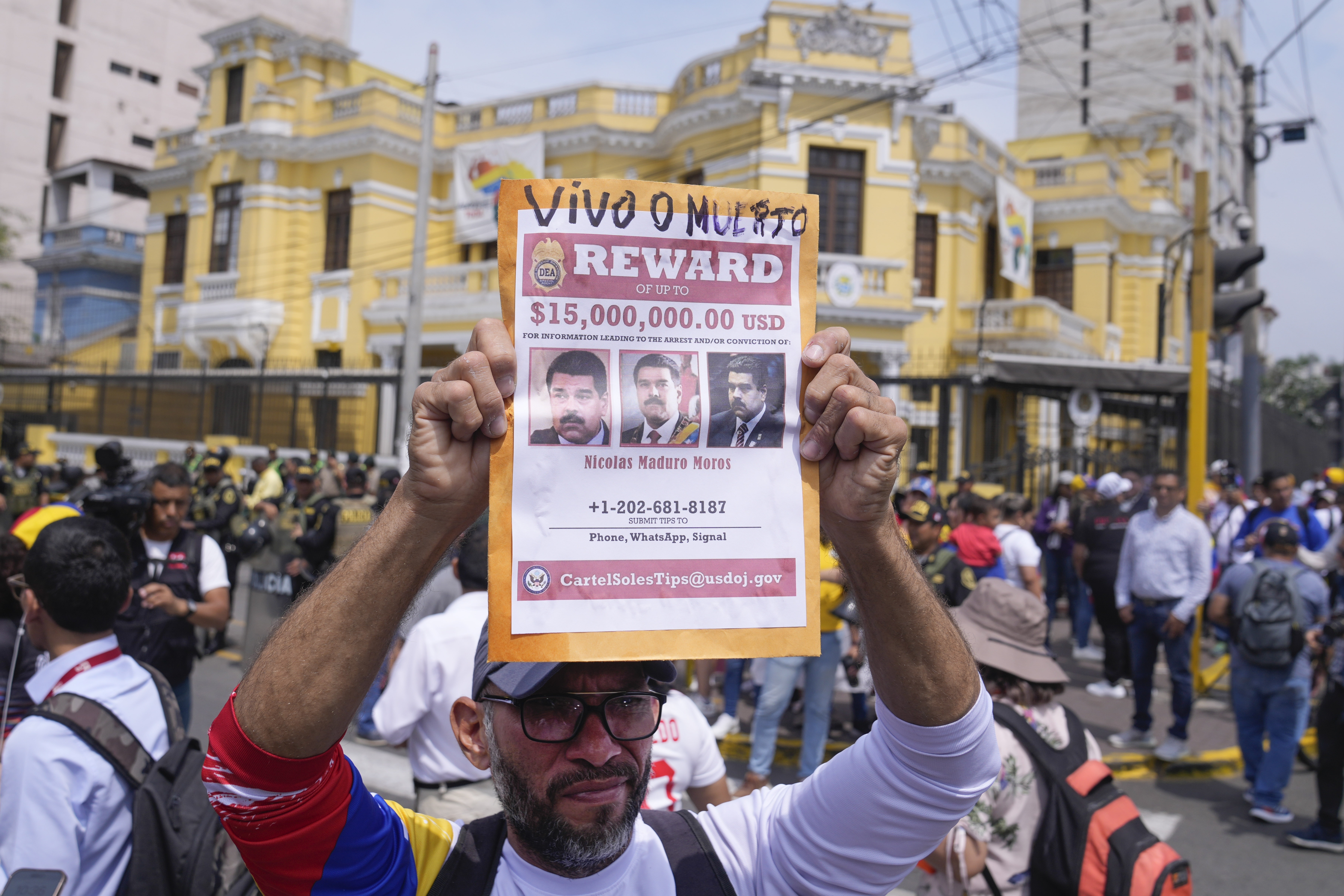 A man holds up a sign advertising the previous $15m bounty