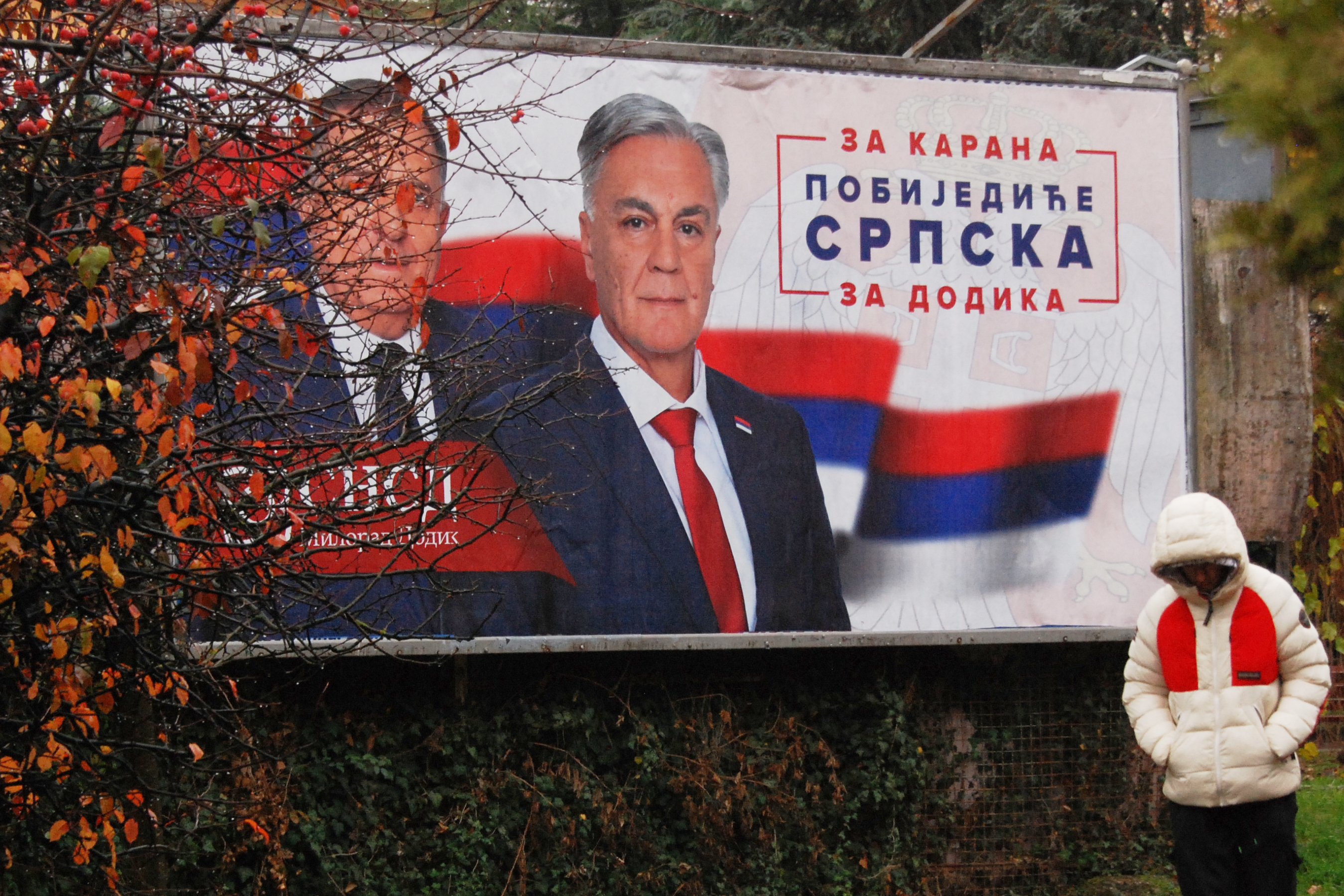 A man walks past an election billboard showing Bosnian Serb leader Milorad Dodik, and his SNSD party's candidate Sinisa Karan, for Republika Srpska's presidential election, in the town of Banja Luka, Friday, November 21, 2025 [Radivoje Pavicic/AP Photo]