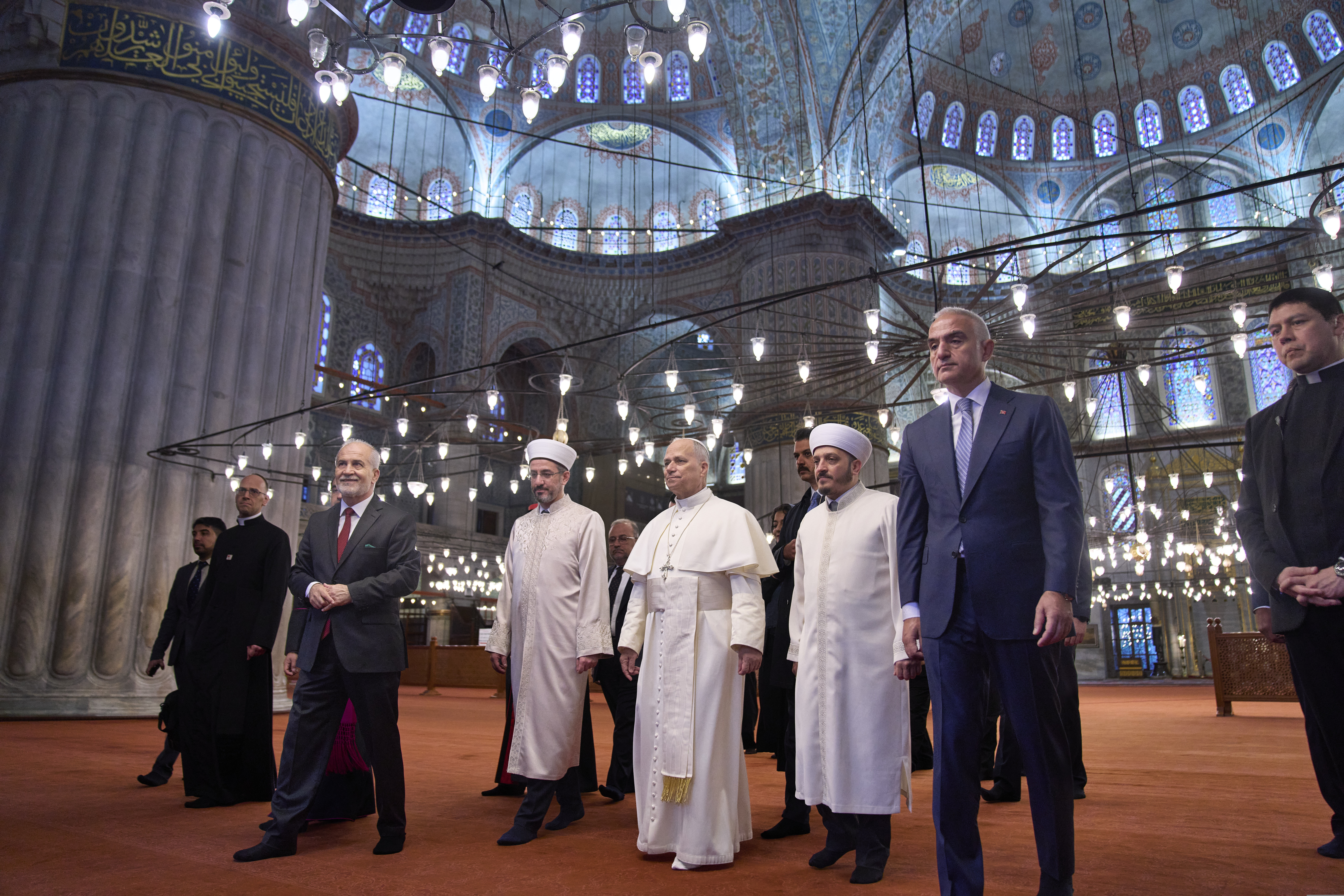 Pope Leo XIV, center, walks with Muezzin Musa Asgın Tunca, third from left, Istanbul's Mufti Emrullah Tuncel, fourth from left, the Imam of Mosque Sultanahmet Fatih Kaya, sixth from left, and Turkish Minister for Culture and Tourism Mehmet Nuri Ersoy, seventh from left, during a visit of the Mosque in Istanbul, Saturday, Nov. 29, 2025