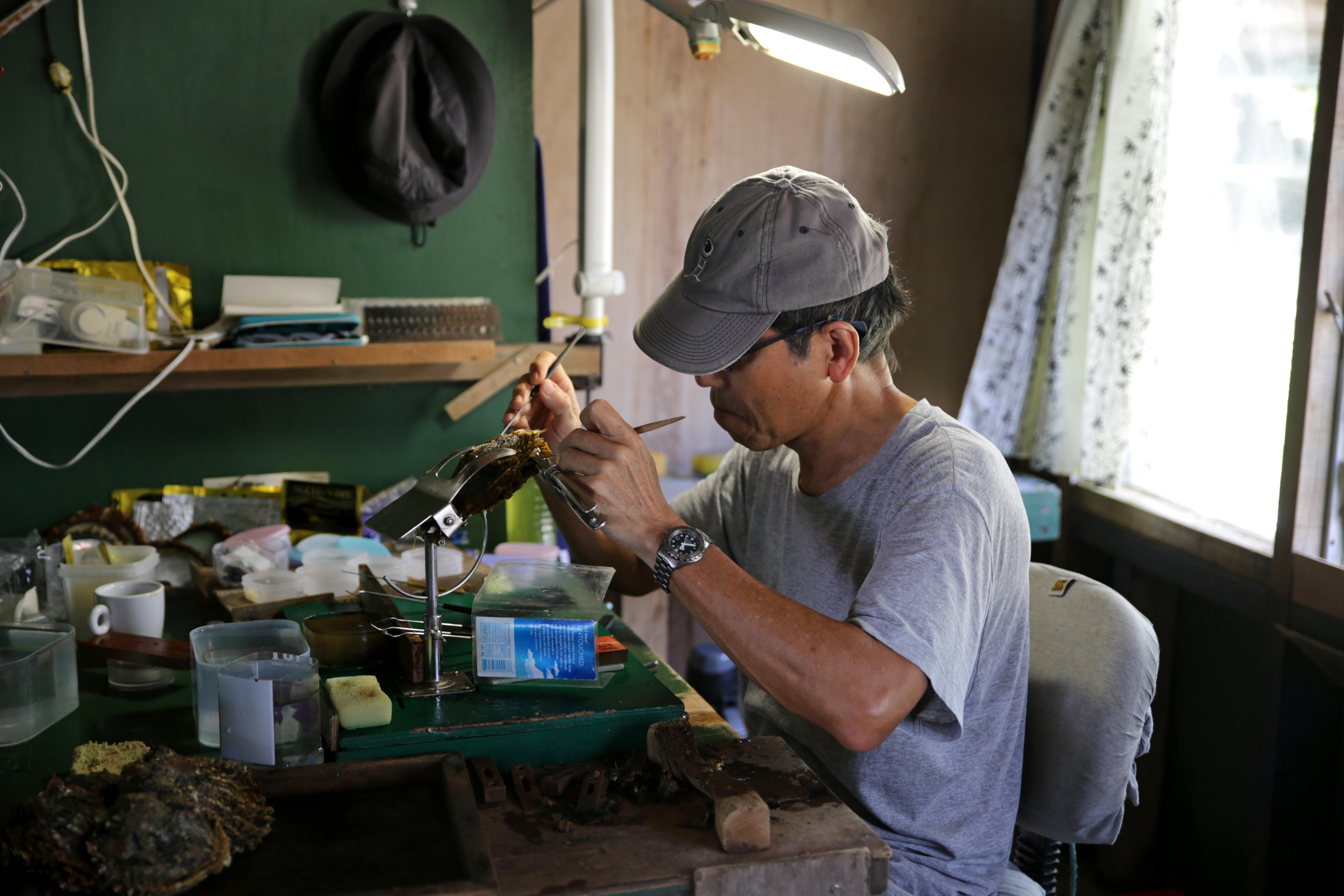 A pearl cultivator works to nucleate an oyster.