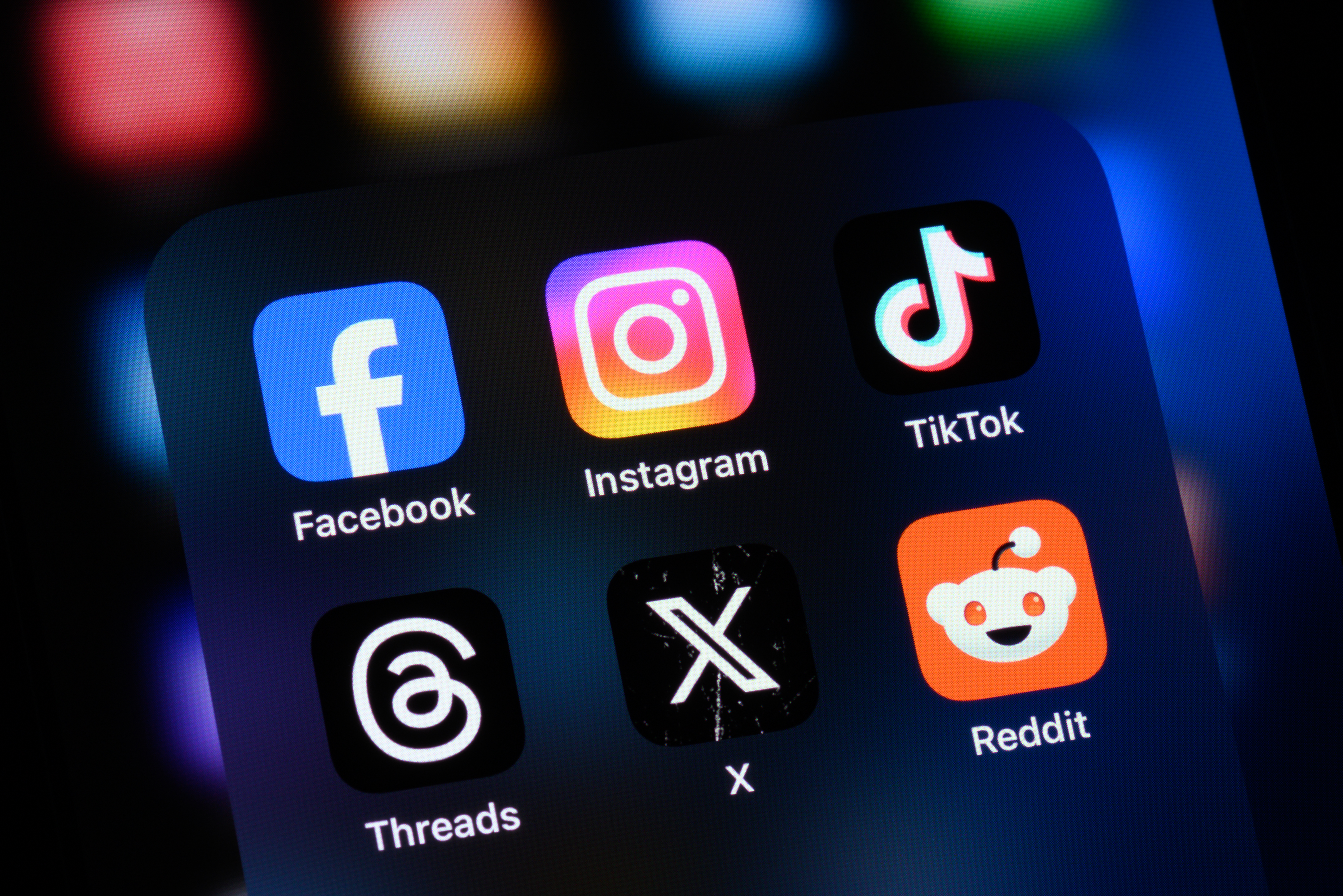 Popular social media apps on an Apple iPhone: Facebook, Instagram, TikTok, Threads, X (formerly Twitter), and Reddit.