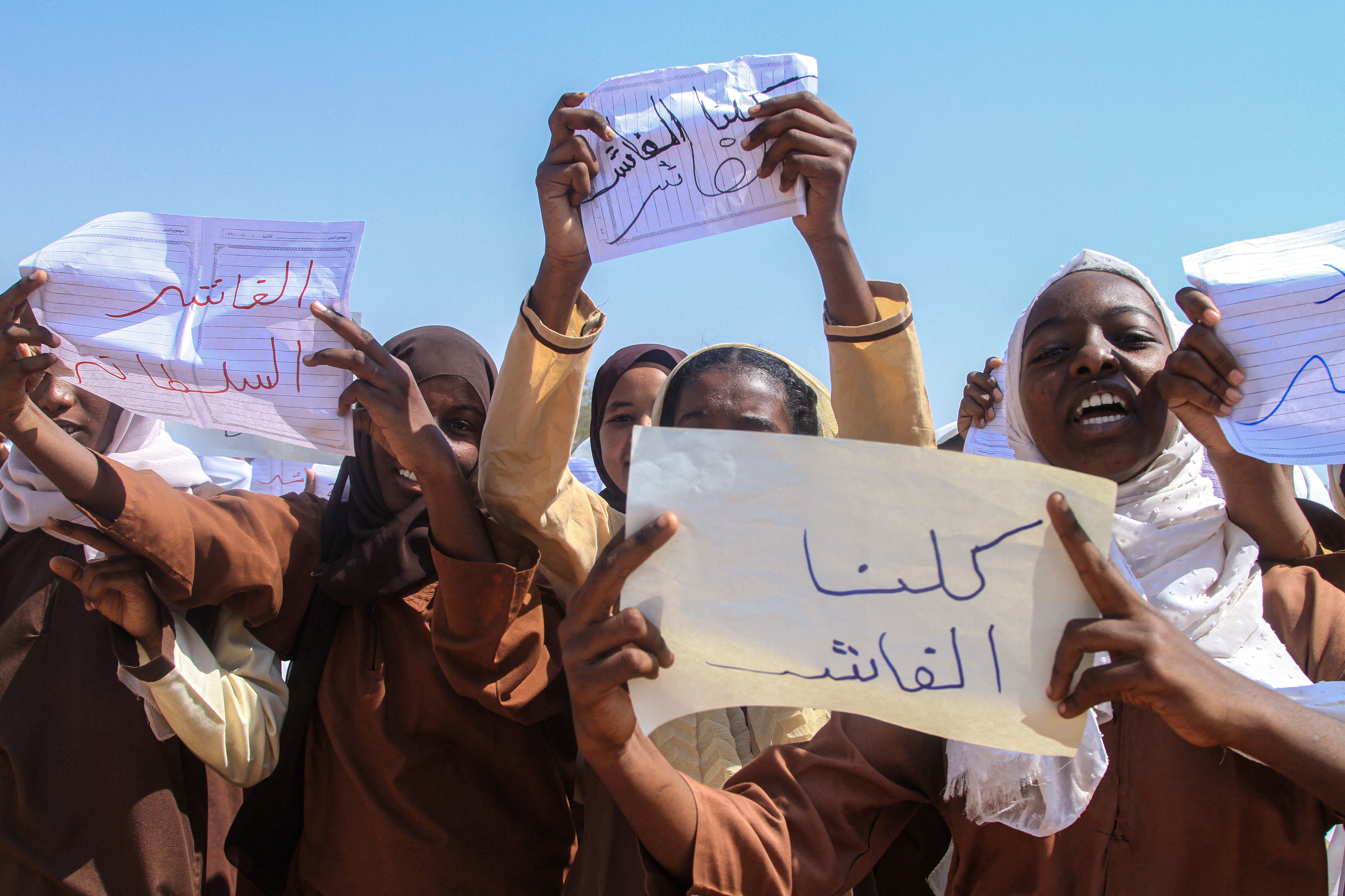 A Sudanese Student from a school in the East Nile region of the capital, holds a sign that reads in Arabic, "We are all El-Fasher" during a protest against violations committed by the Rapid Support Forces (RSF) against the people of El- Fasher, in Khartoum on November 3, 2025.