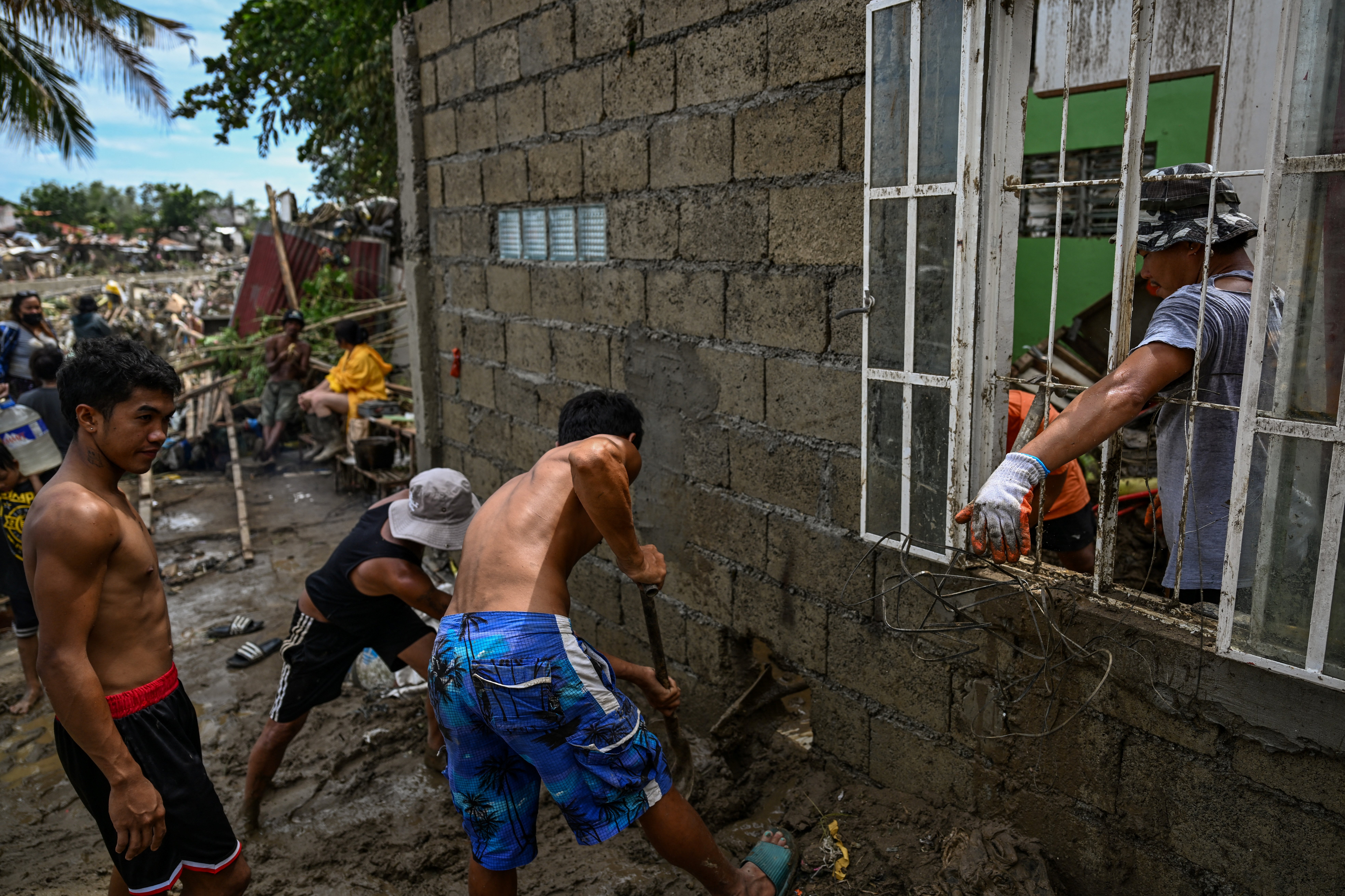 Residents clean up their damaged houses in the aftermath of Typhoon Kalmaegi in Talisay, in the province of Cebu on November 5, 2025. (Photo by Jam STA ROSA / AFP)
