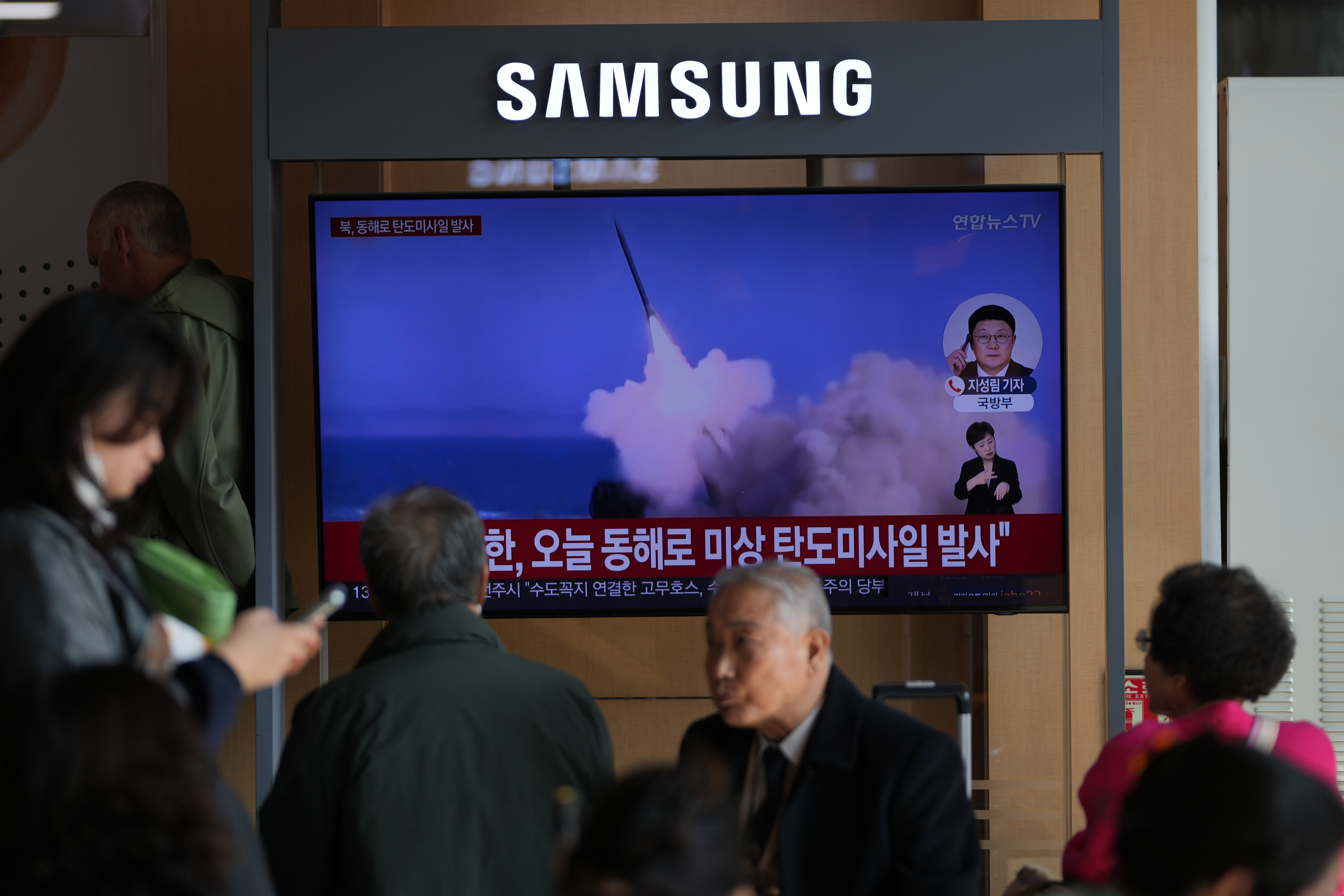A TV screen shows footage of missiles.